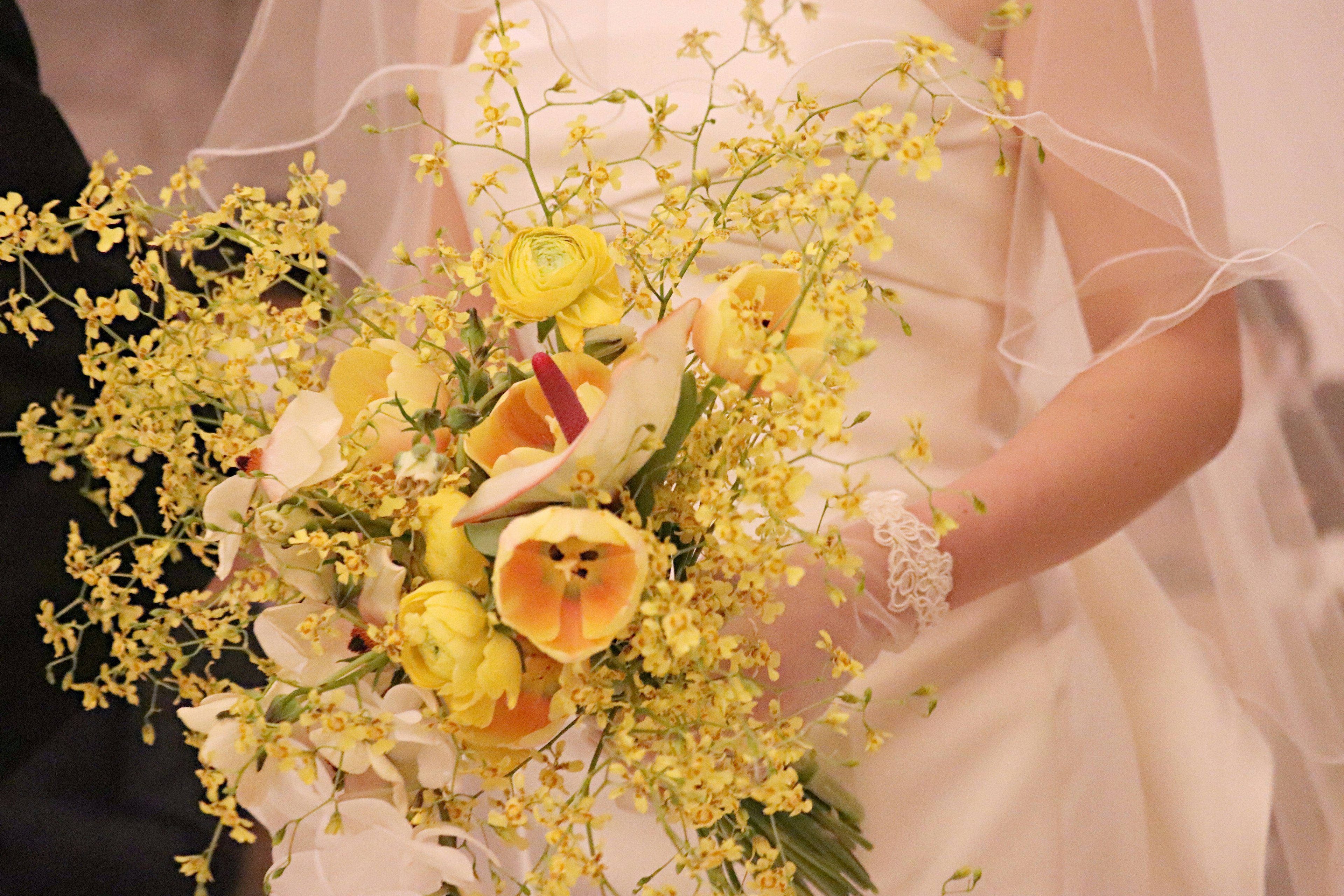 Novia sosteniendo un ramo con flores amarillas y follaje