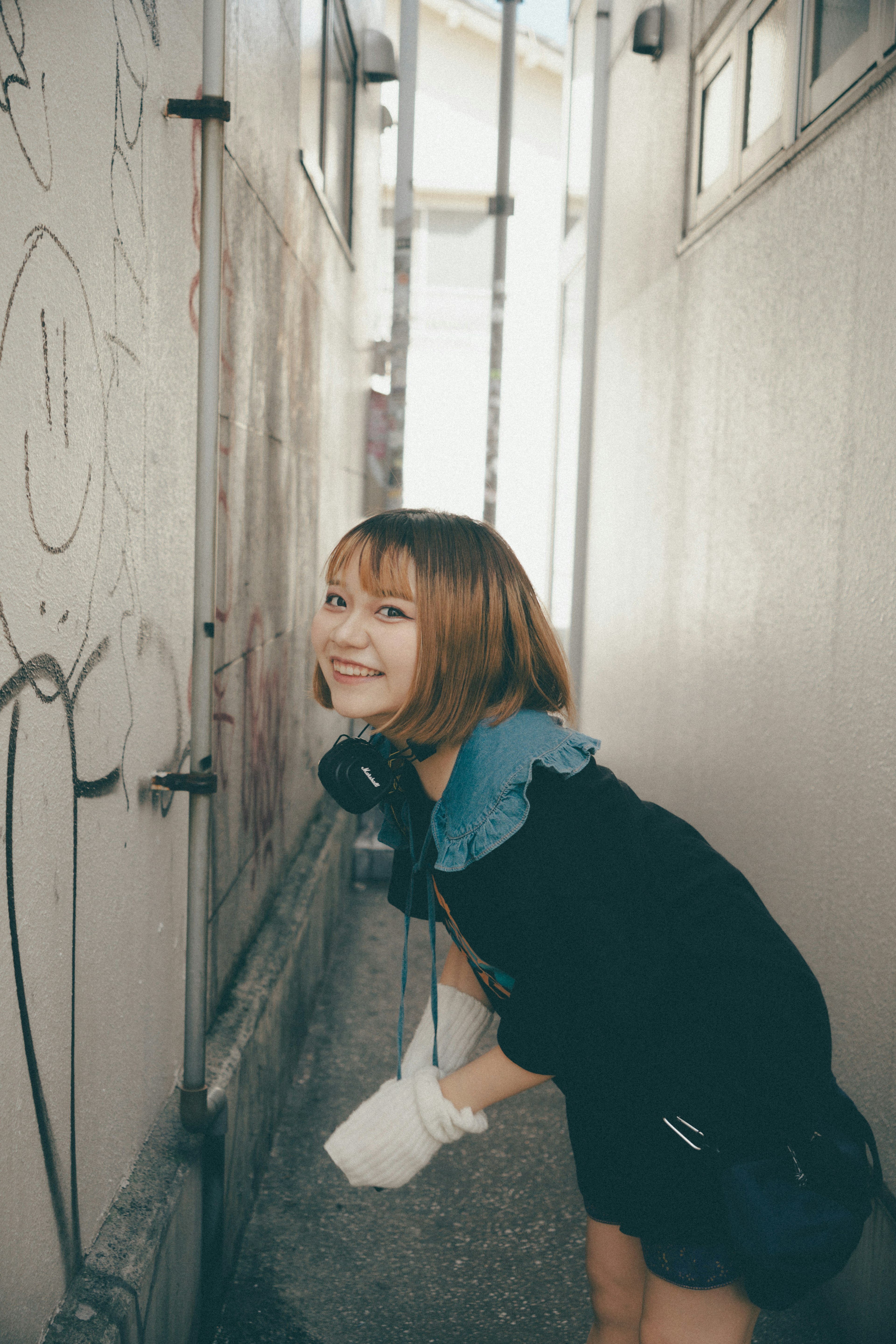 Young woman smiling in a narrow alleyway