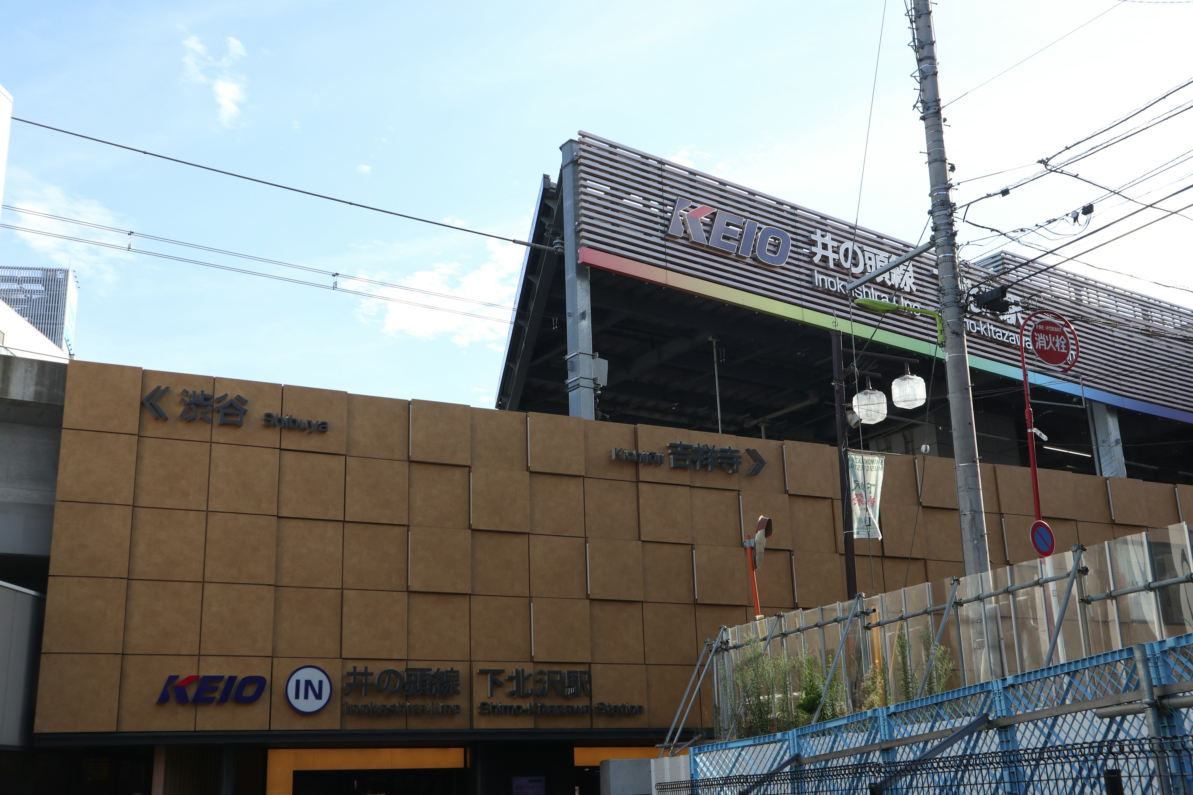 Vue extérieure d'un bâtiment avec des logos Keio et une signalisation colorée