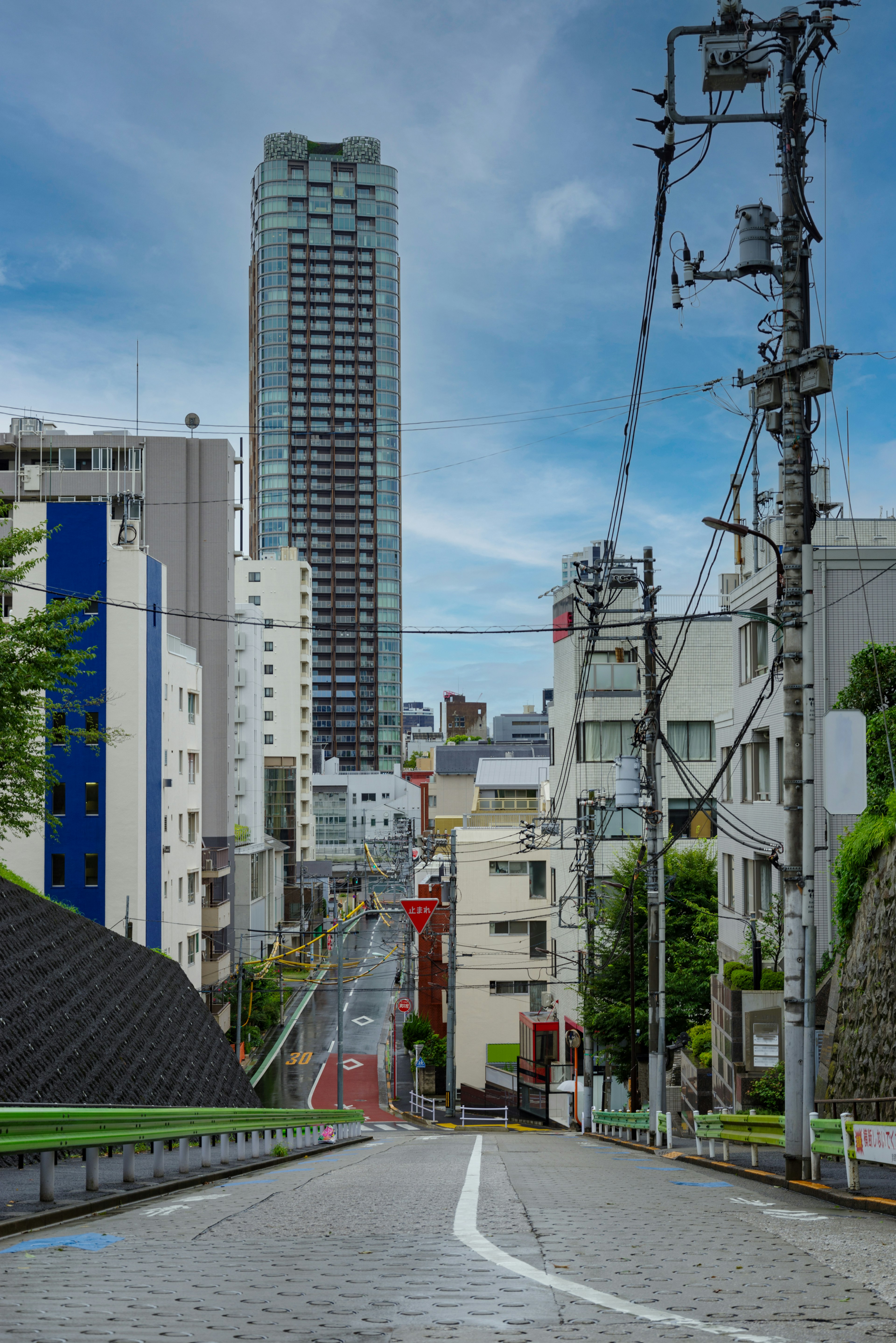 Strada in pendenza a Tokyo con vista sulla città e grattacieli