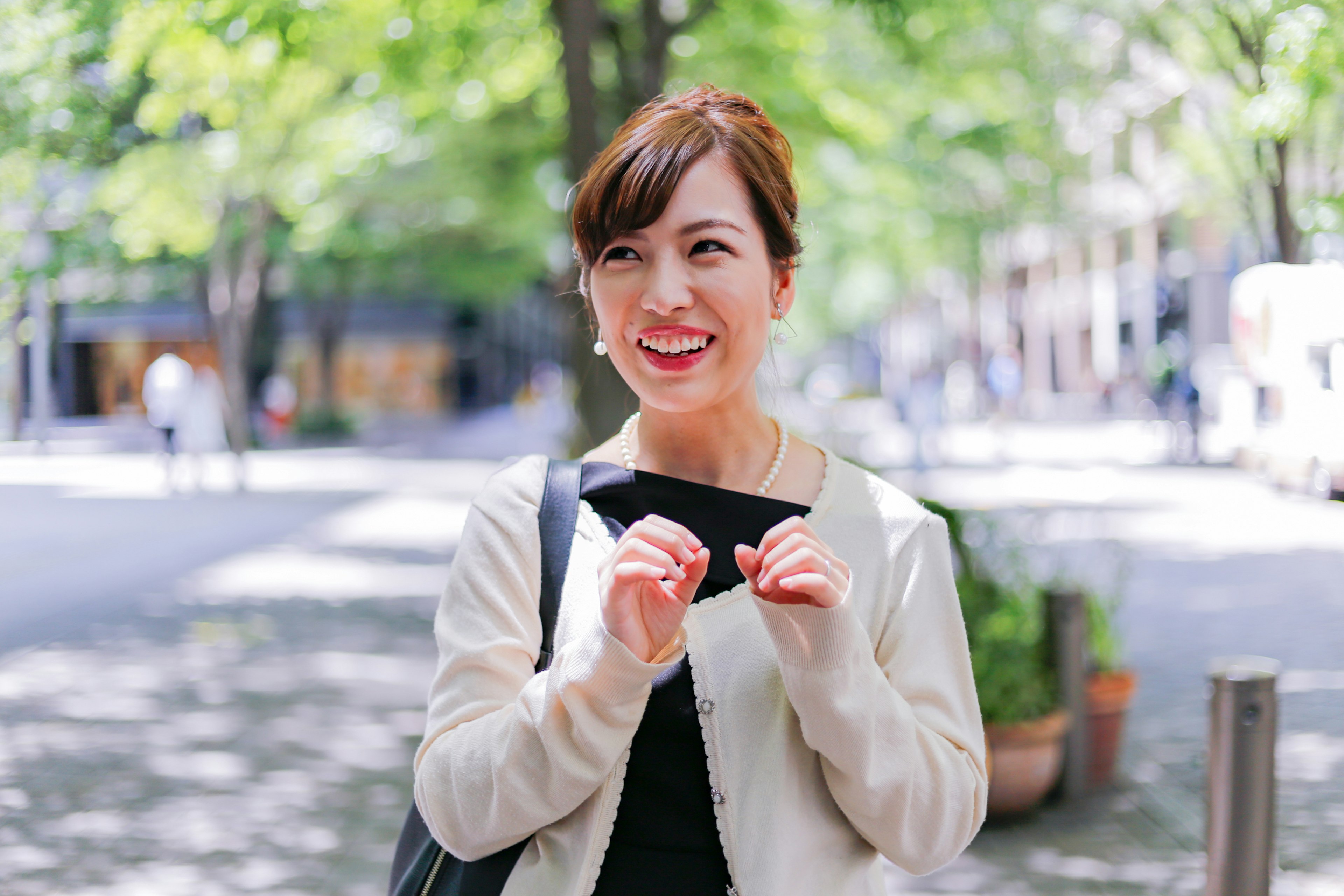 A smiling woman gesturing with her hands in a park