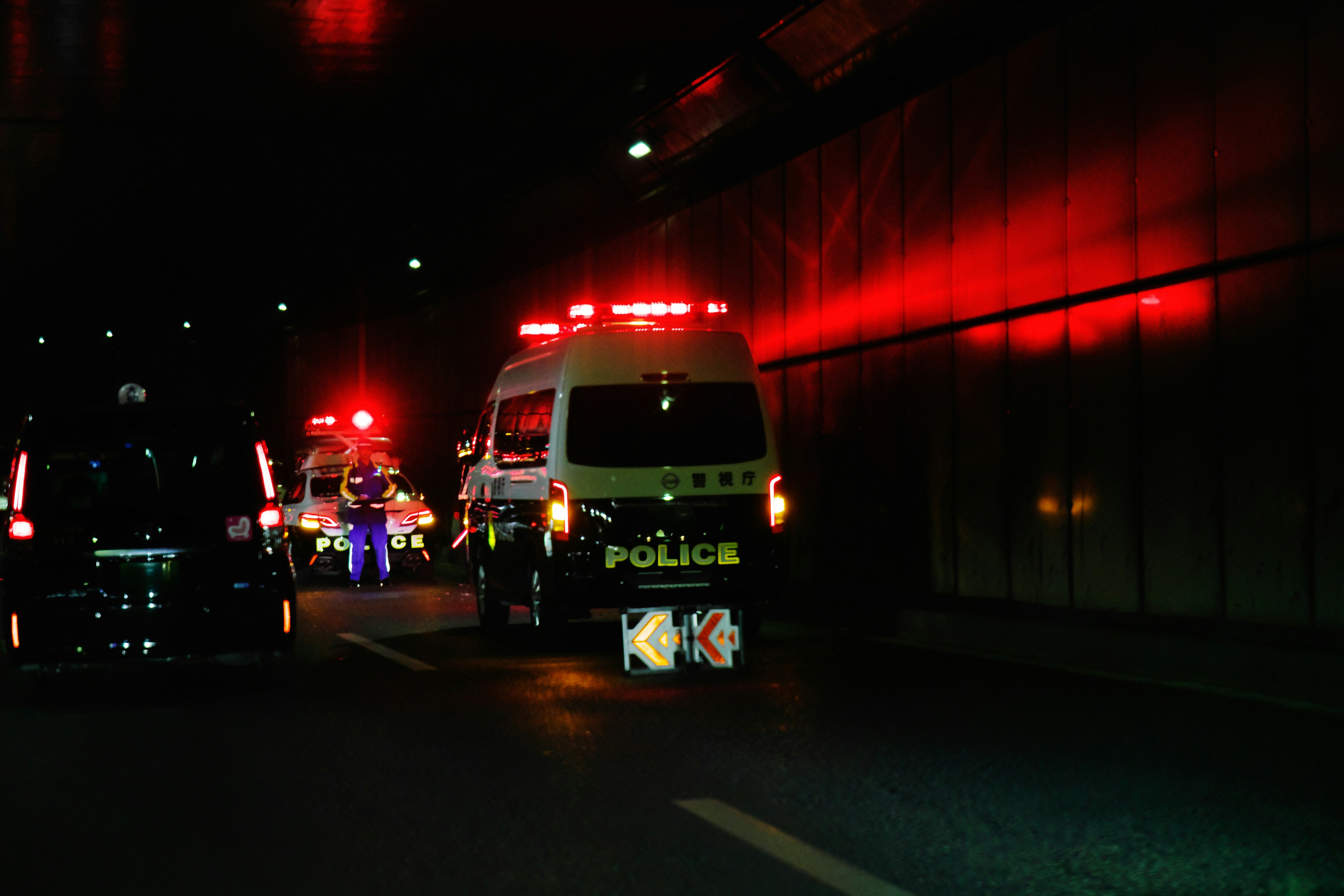 Kendaraan polisi berhenti di dalam terowongan dengan pencahayaan merah