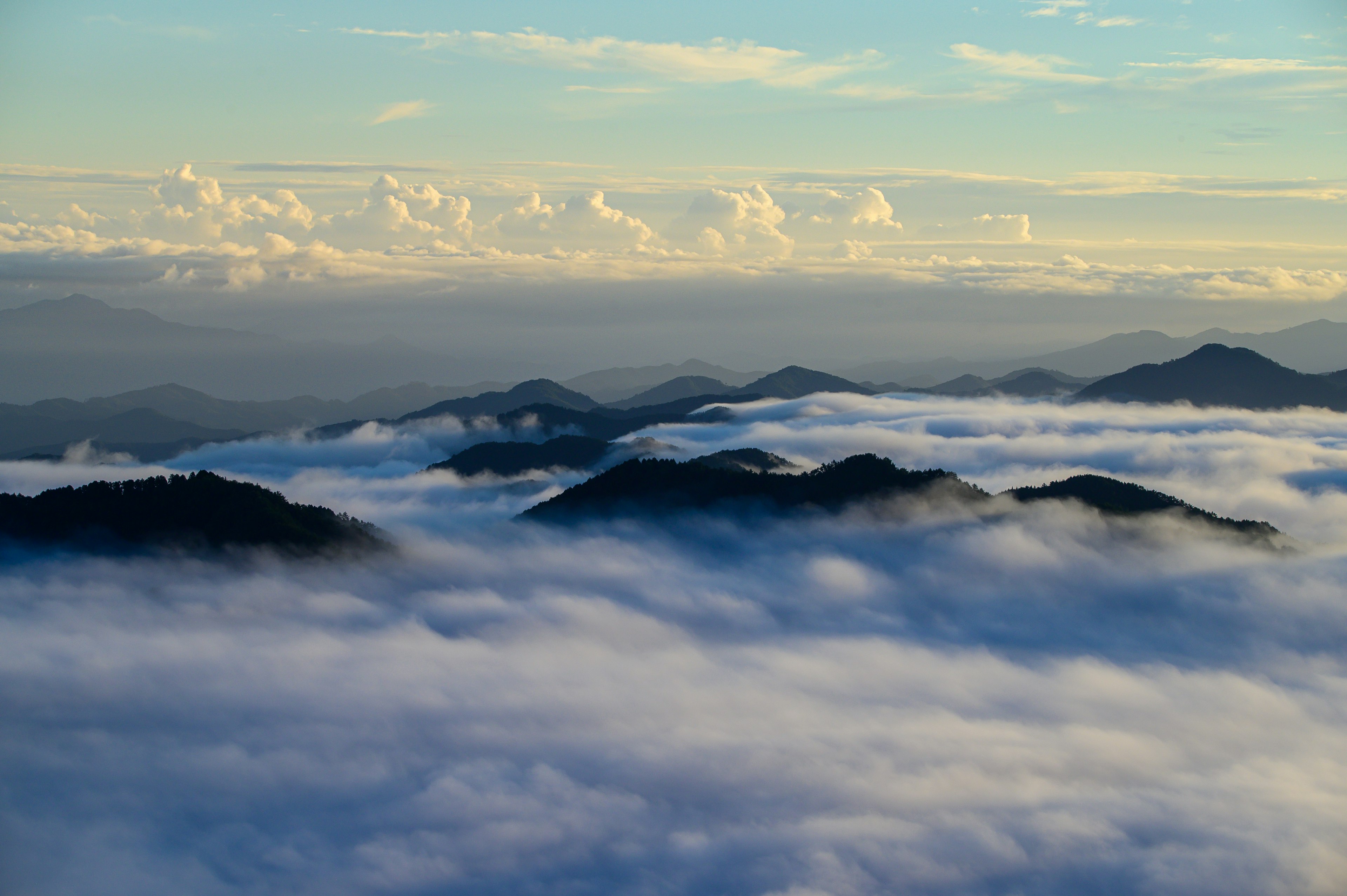 Stunning landscape of mountains floating above a sea of clouds