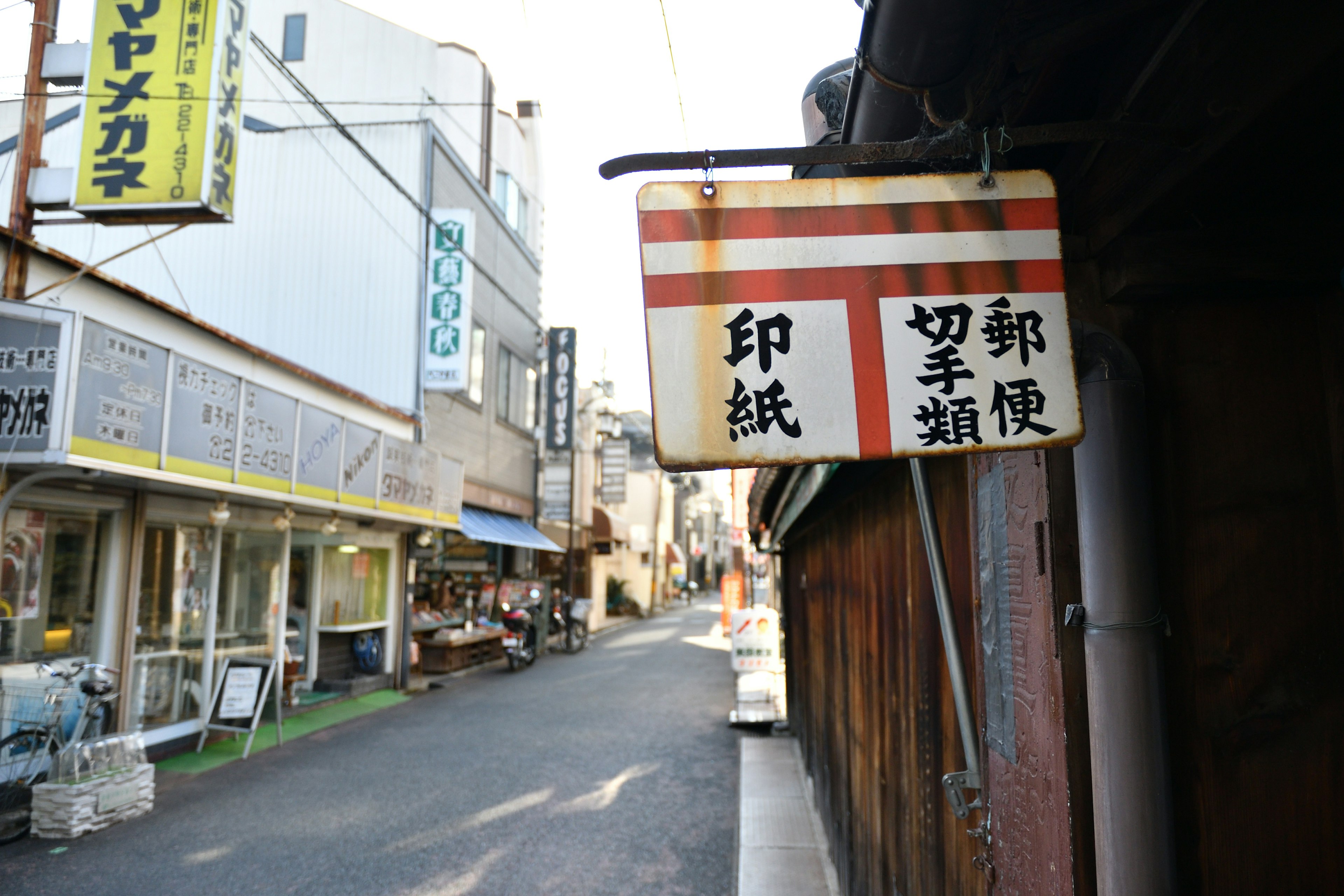 ตรอกแคบที่มีป้ายเก่าและร้านค้า