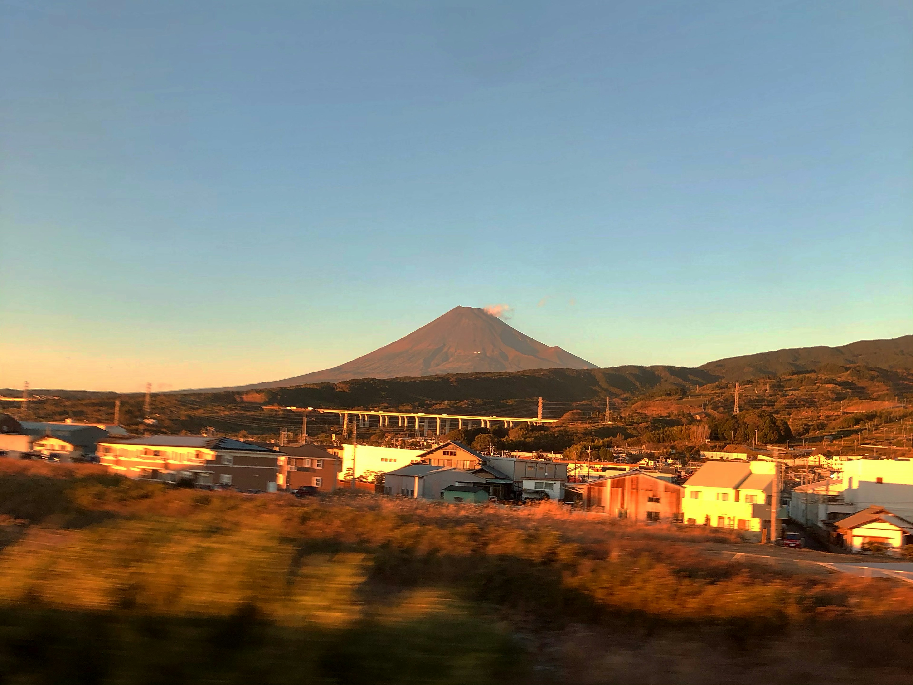 Vue panoramique du mont Fuji au coucher du soleil avec une ville voisine