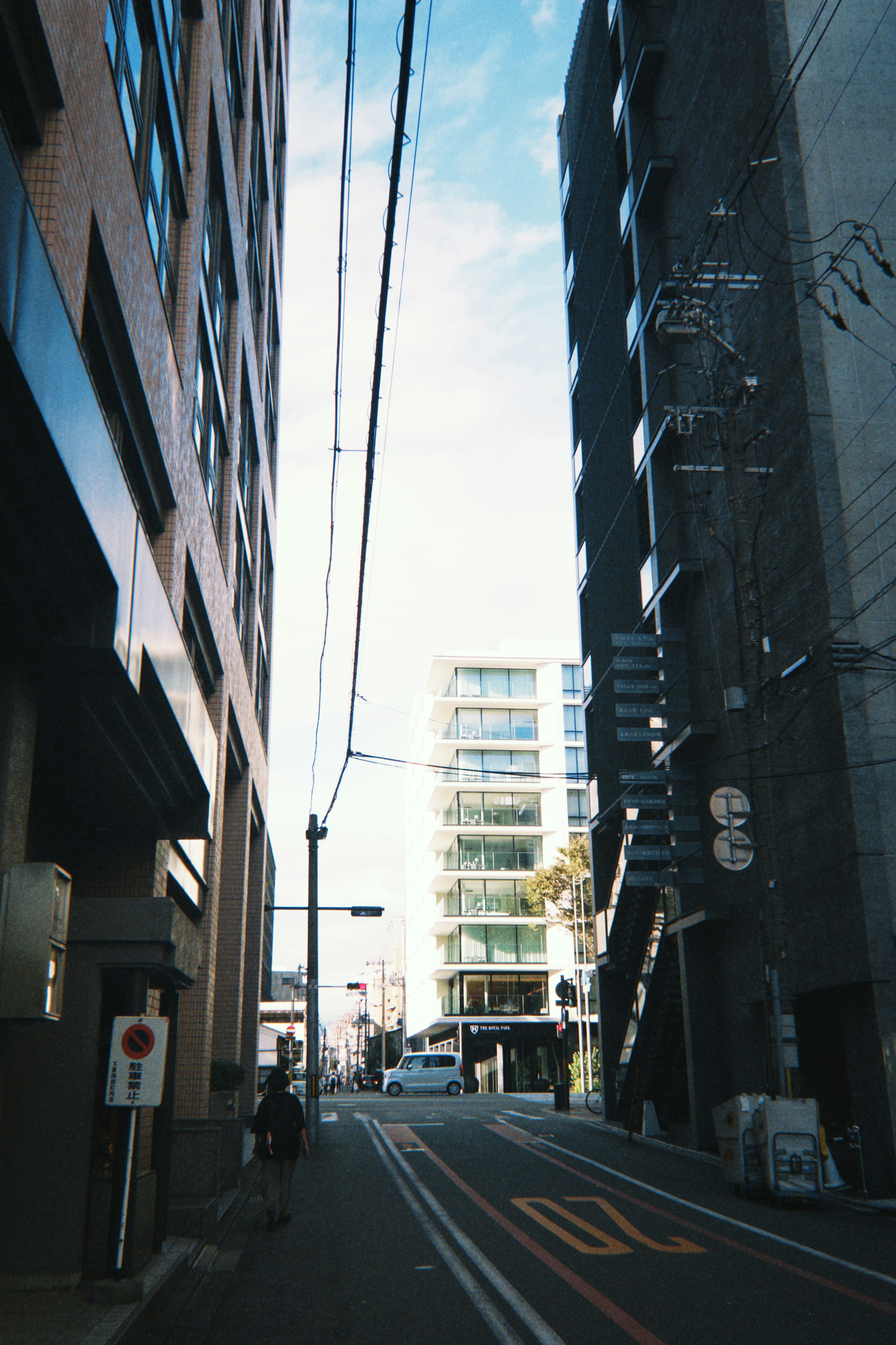 Calle estrecha flanqueada por edificios y cielo despejado