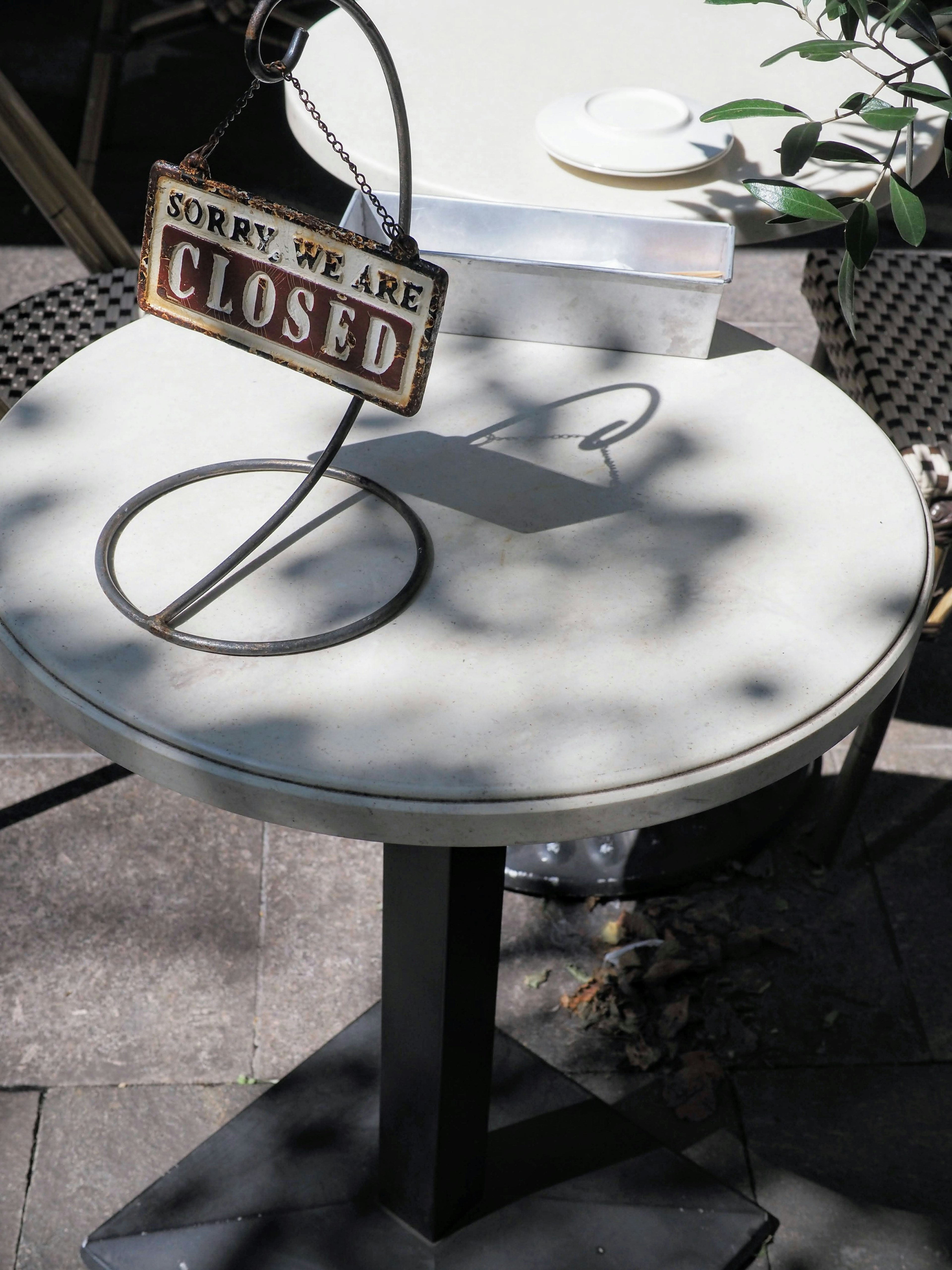 Mesa con un letrero de cerrado y sombras proyectadas en su superficie