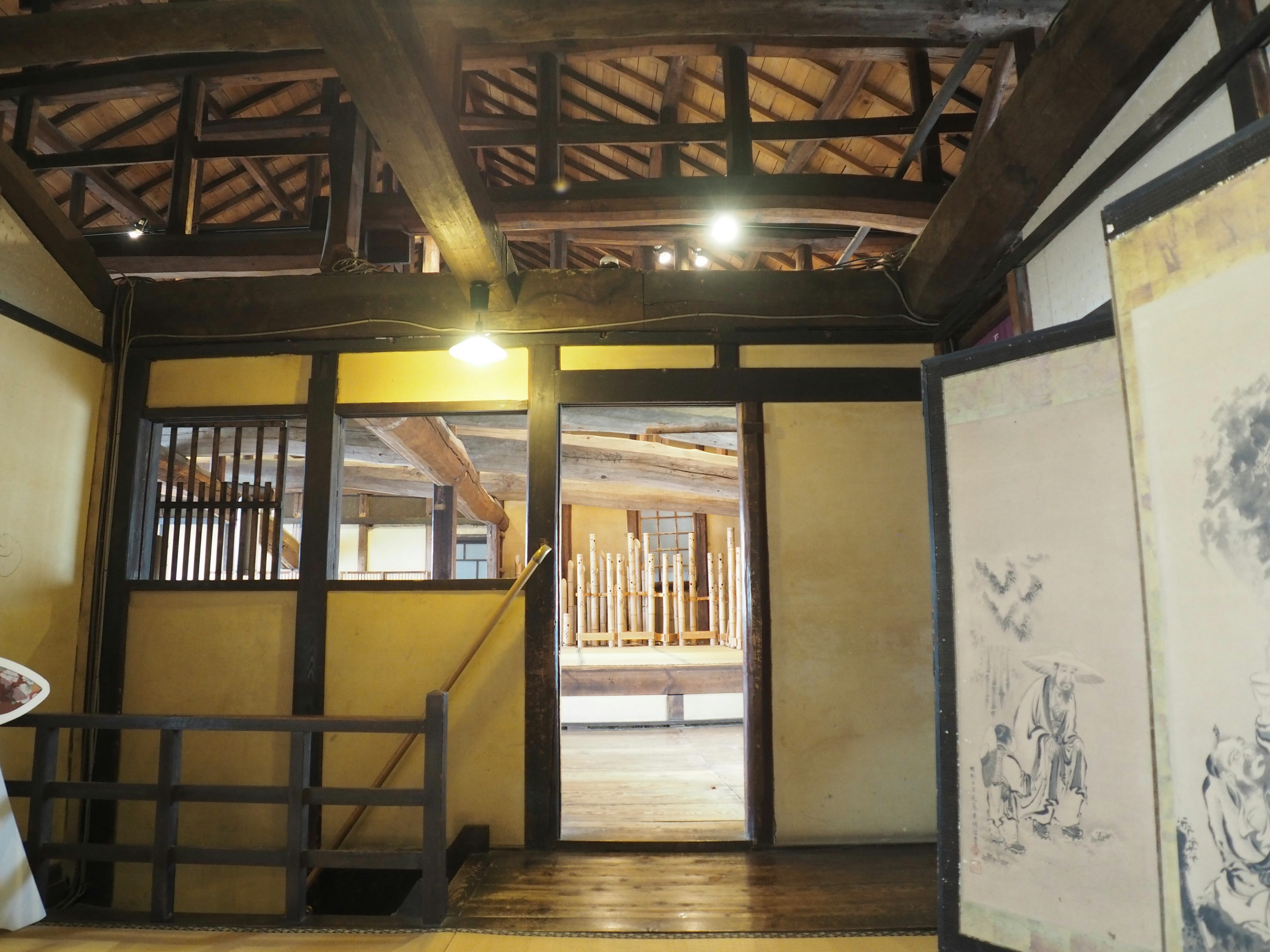 Vista interior de una casa japonesa tradicional con vigas de madera y puertas corredizas