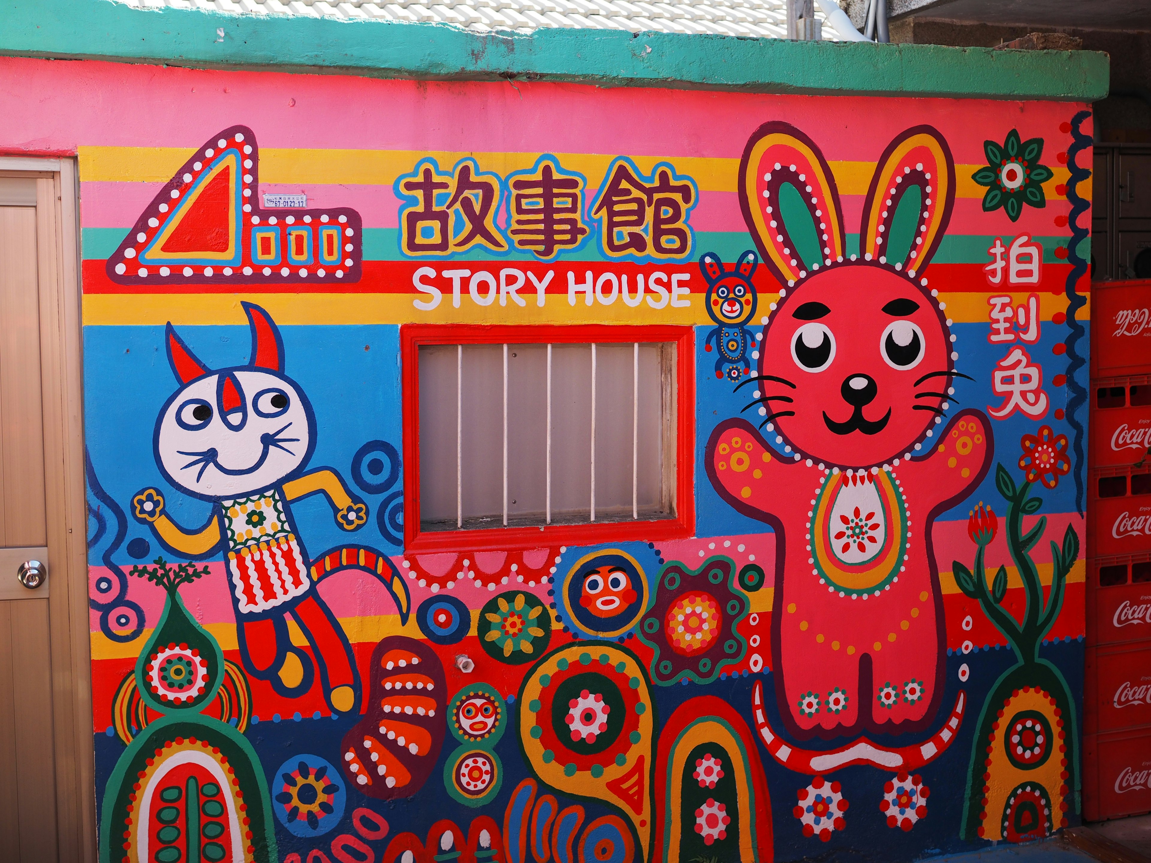 Mural coloré d'une maison d'histoires avec un lapin vibrant et des illustrations de personnages