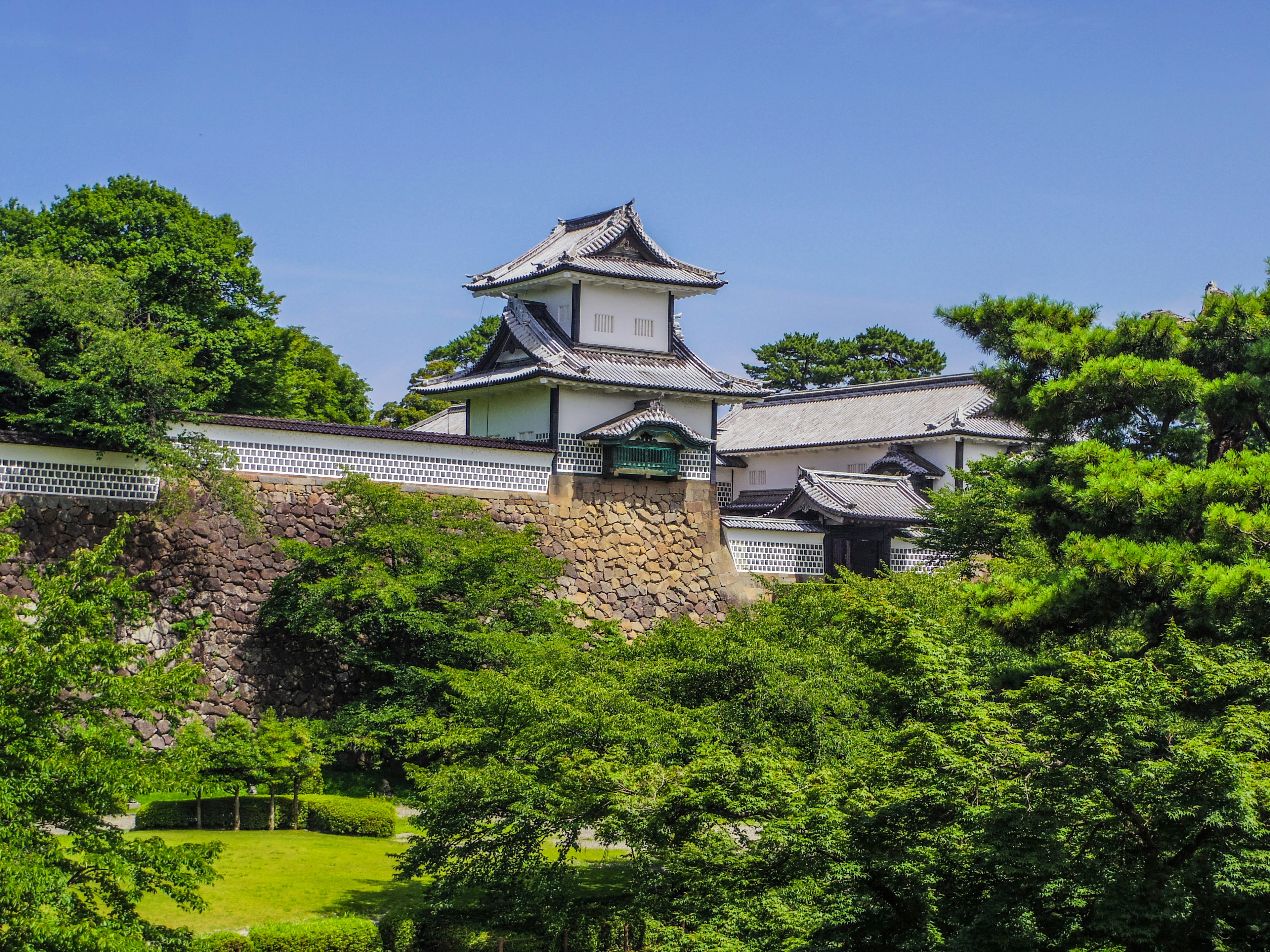 緑に囲まれた歴史的な城の建物と青い空