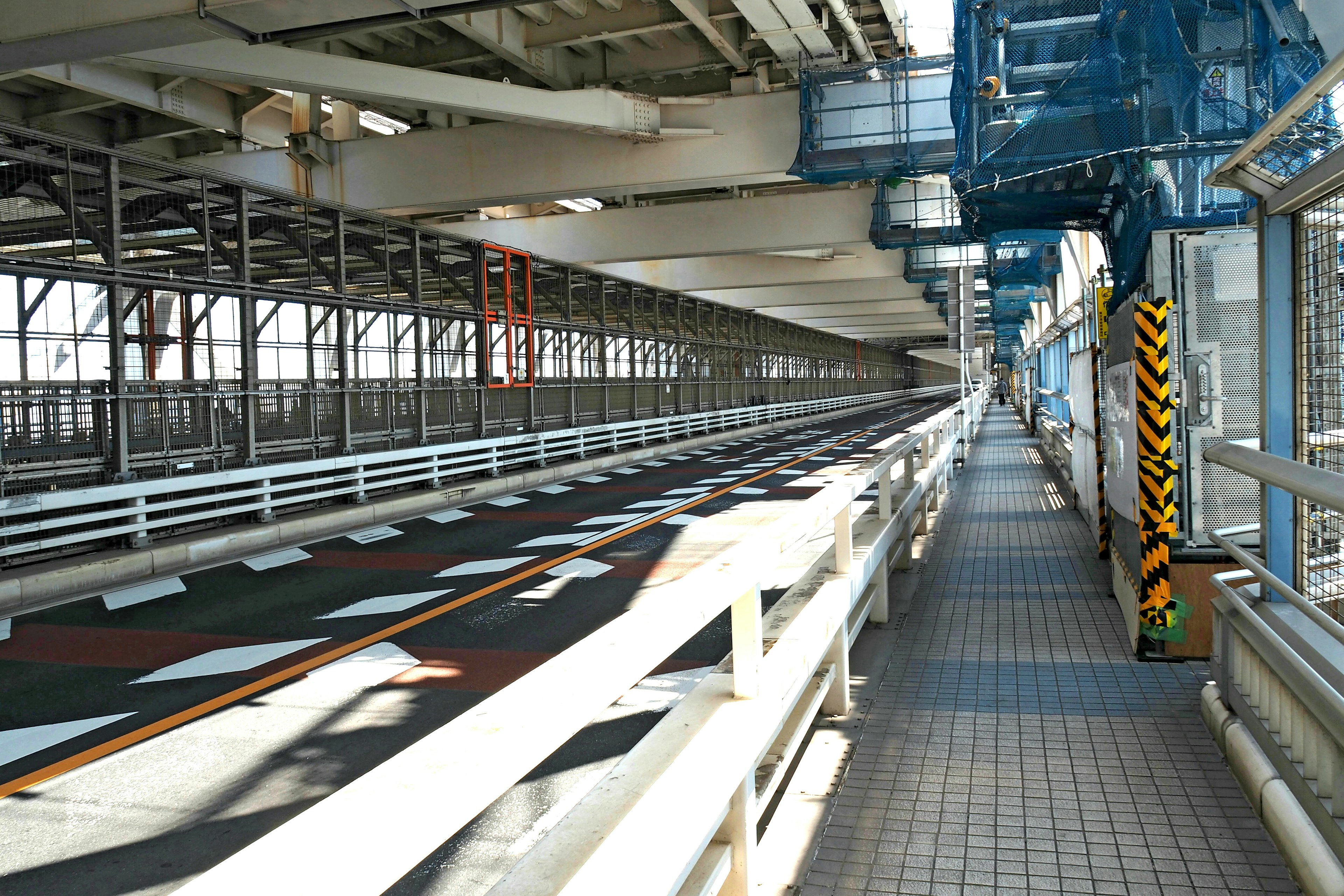 Vista interna di un ponte che mostra elementi strutturali e un marciapiede