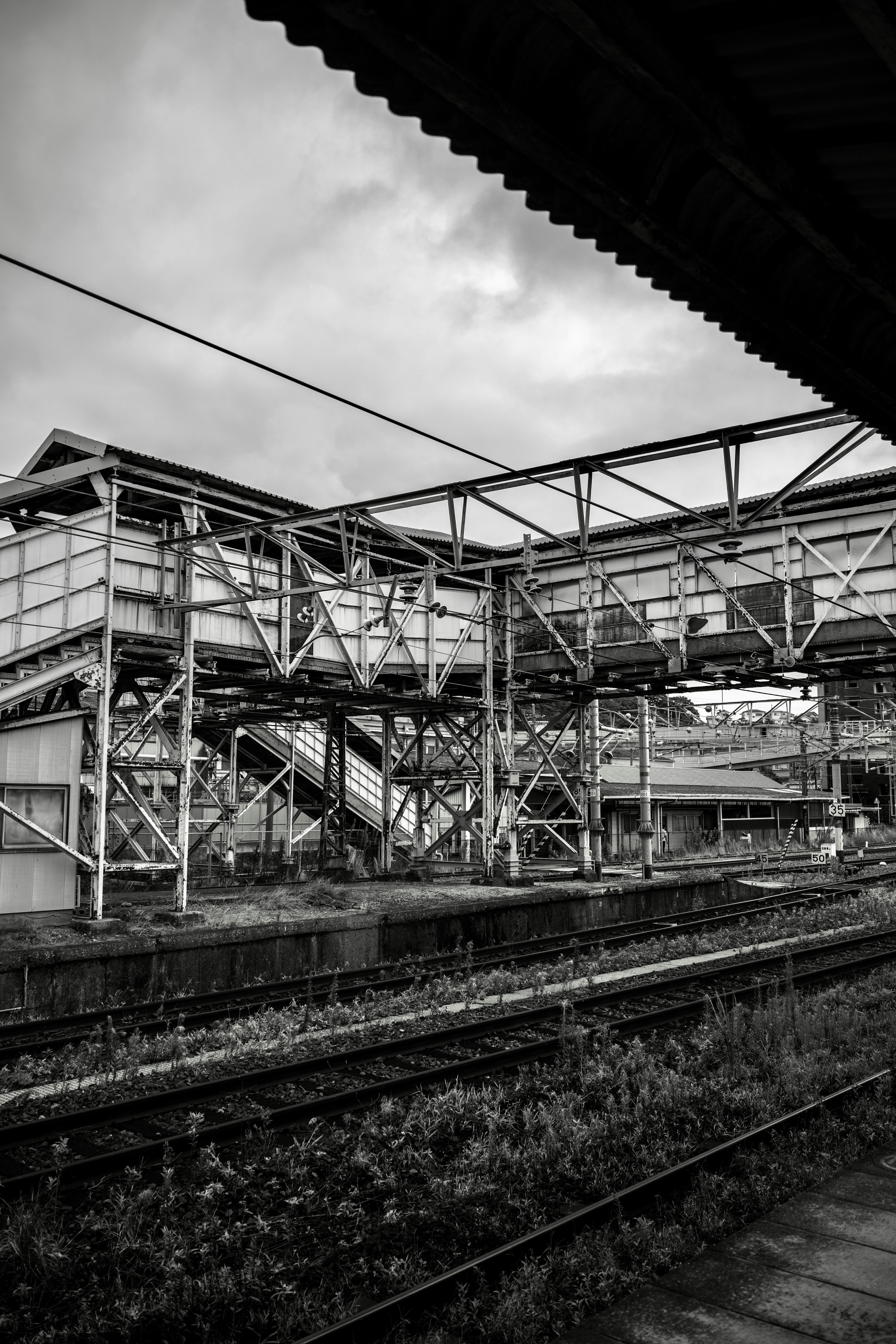 鉄道駅の構造物と線路のモノクロ写真