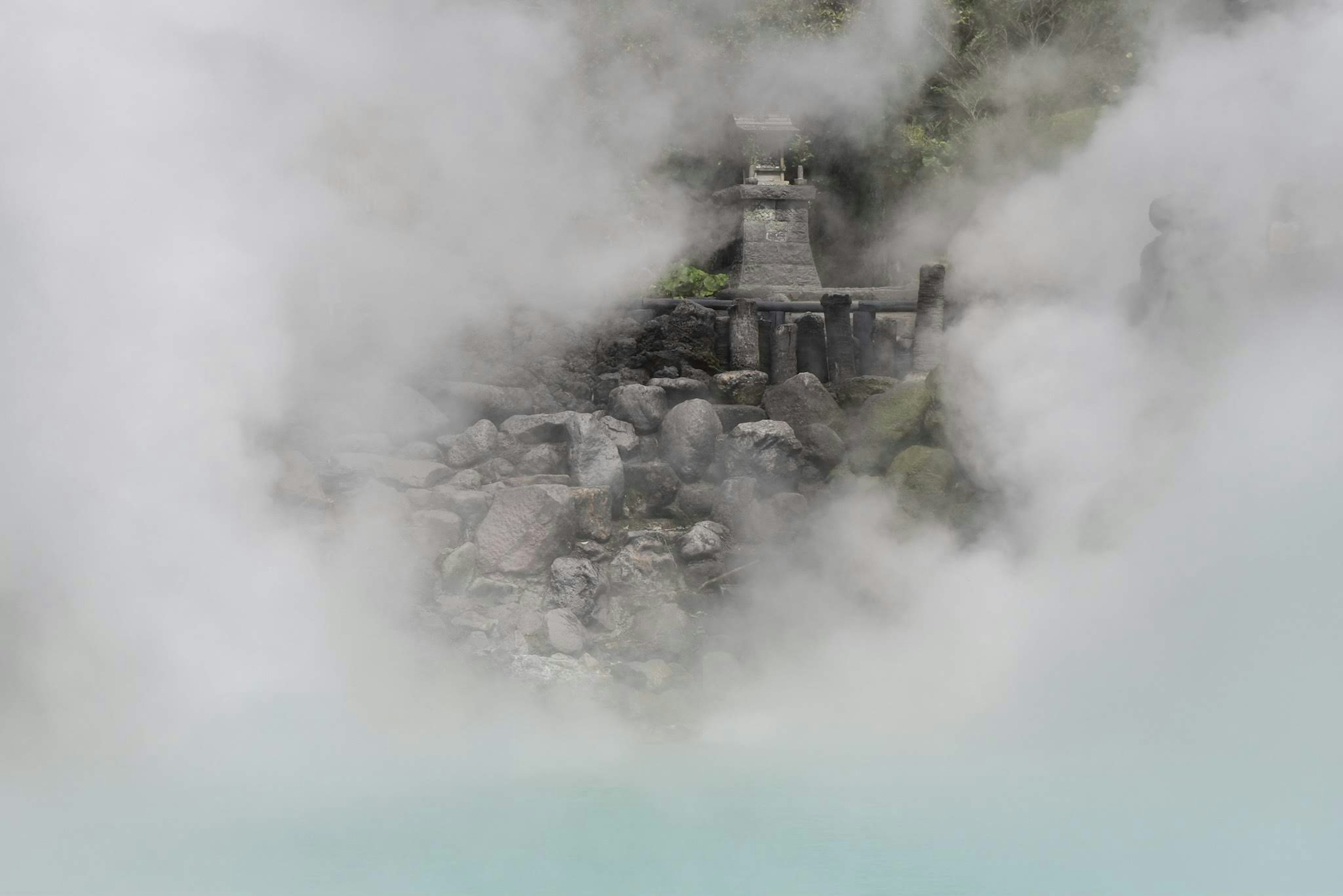 Pemandangan pemandian air panas yang berkabut dengan batu dan menara