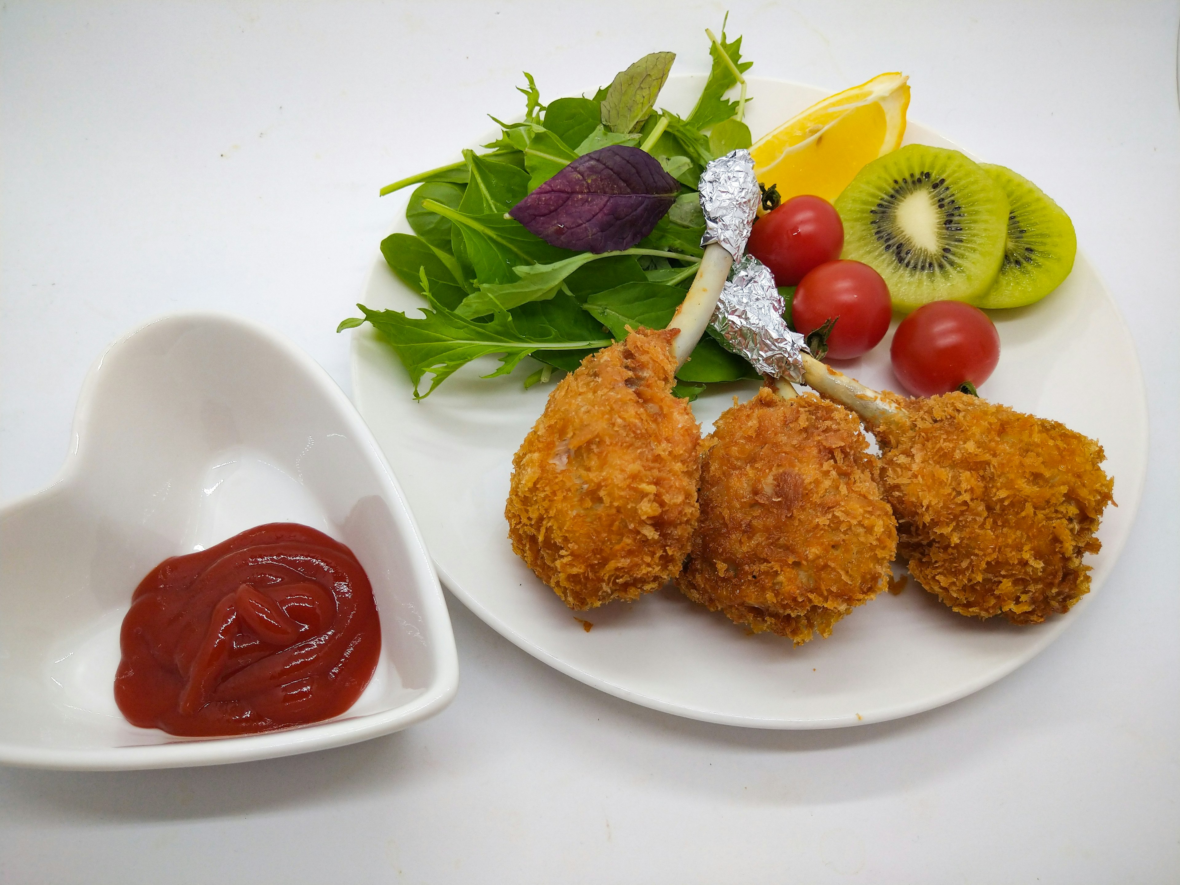 Teller mit frittiertem Hühnchen, Salat und Ketchup daneben