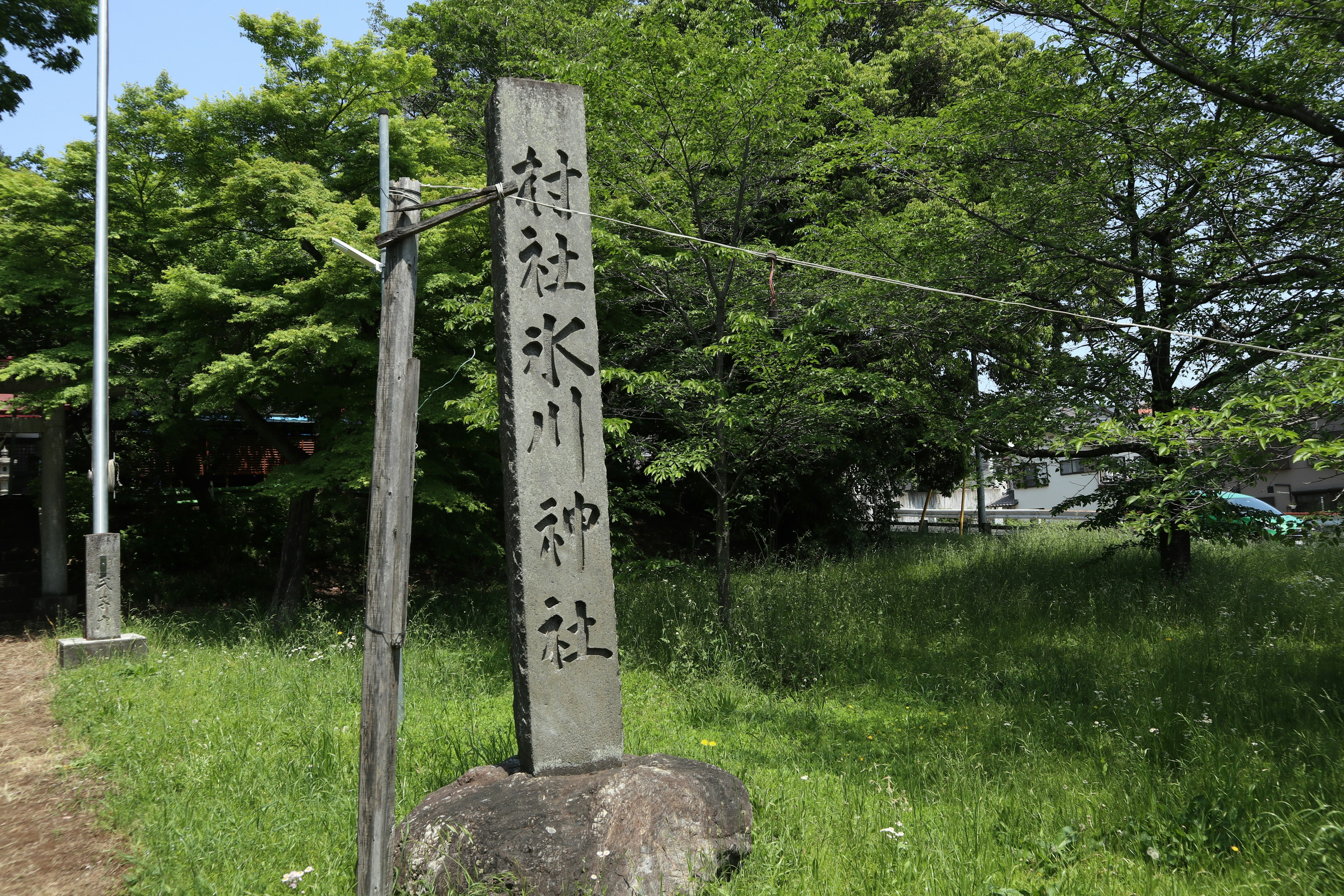 Stone monument of a shrine standing in a grassy area