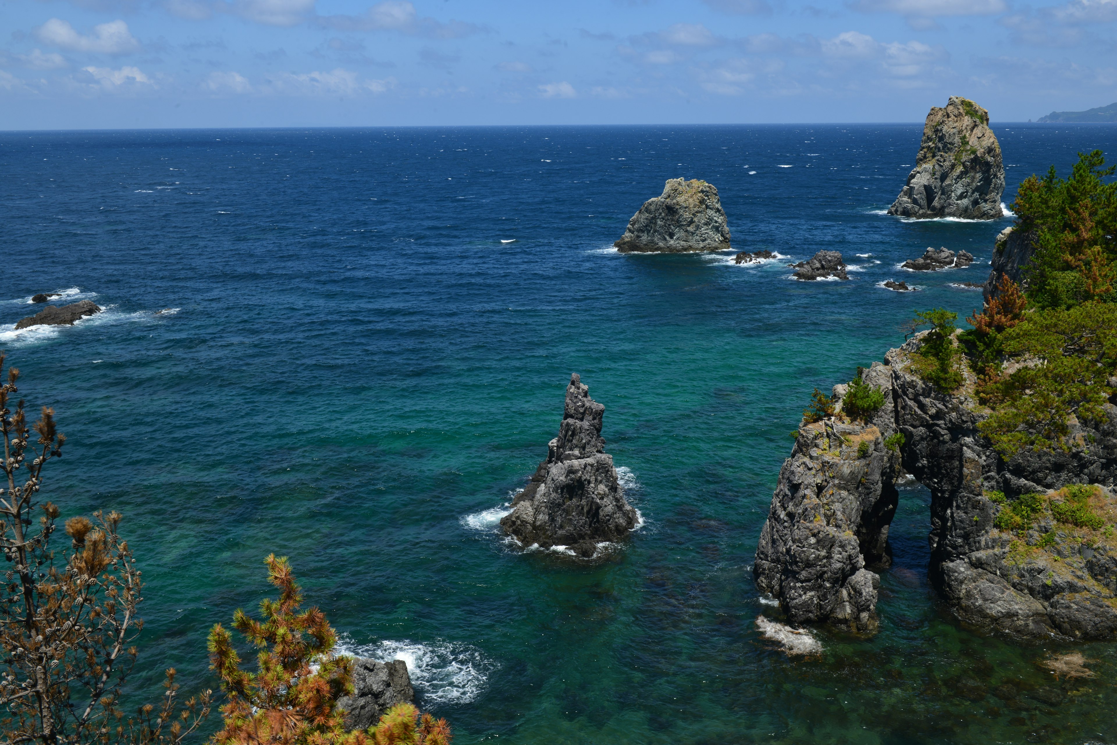 Scenic view of blue ocean with rock formations and arches