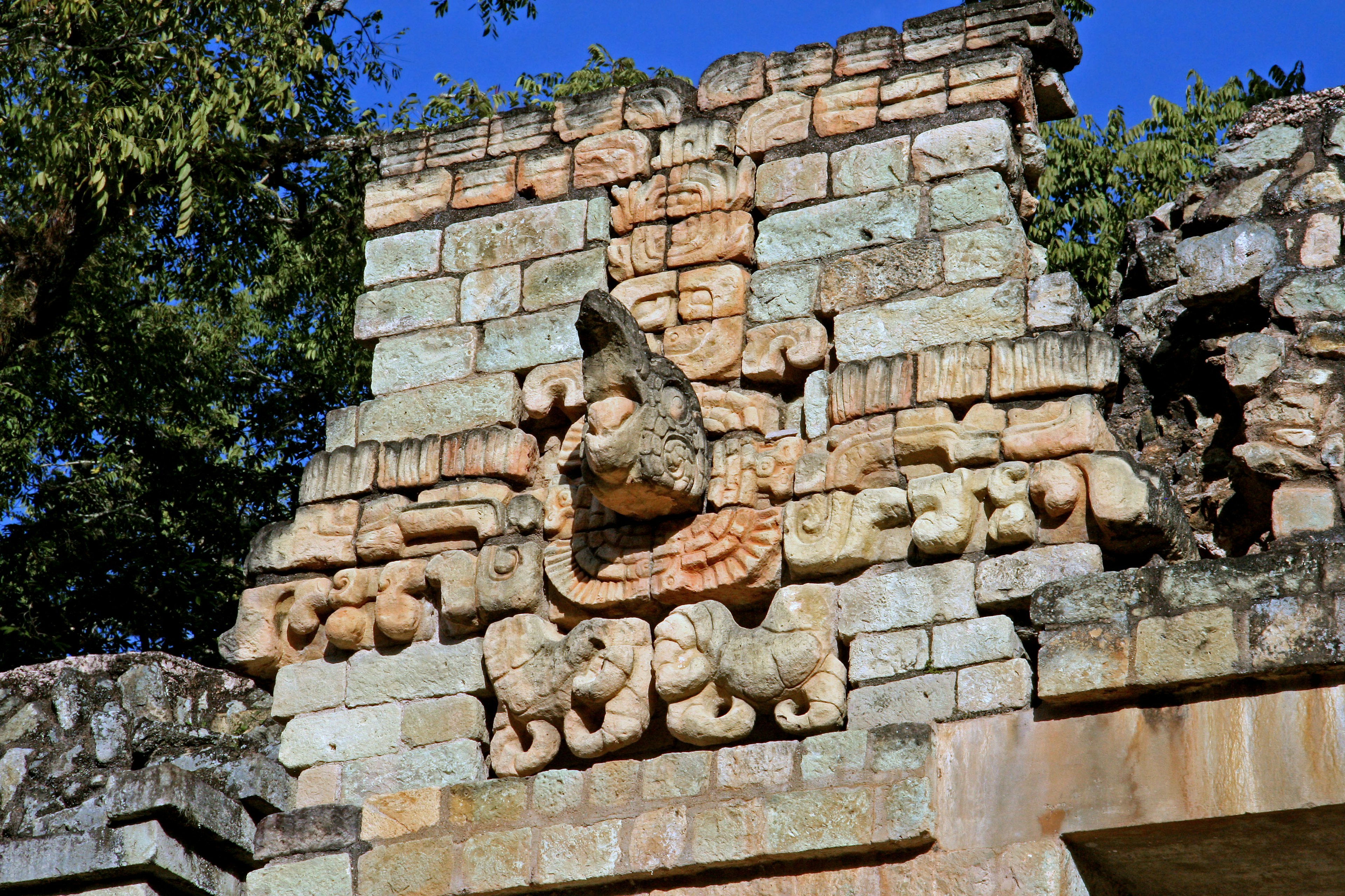 Partie d'une structure en pierre avec des sculptures mayas anciennes