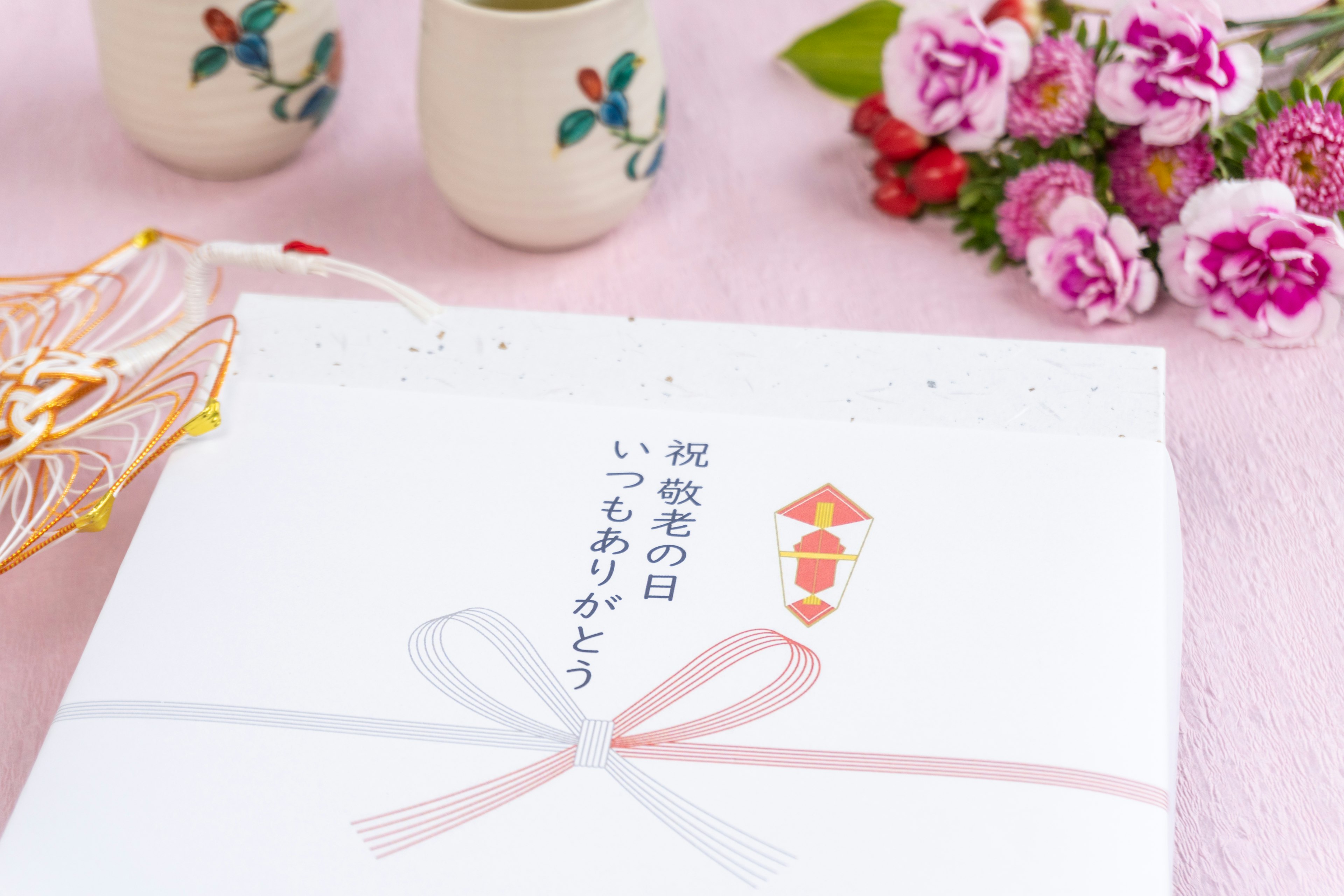 Japanese gift package with a white wrapping and pink ribbon