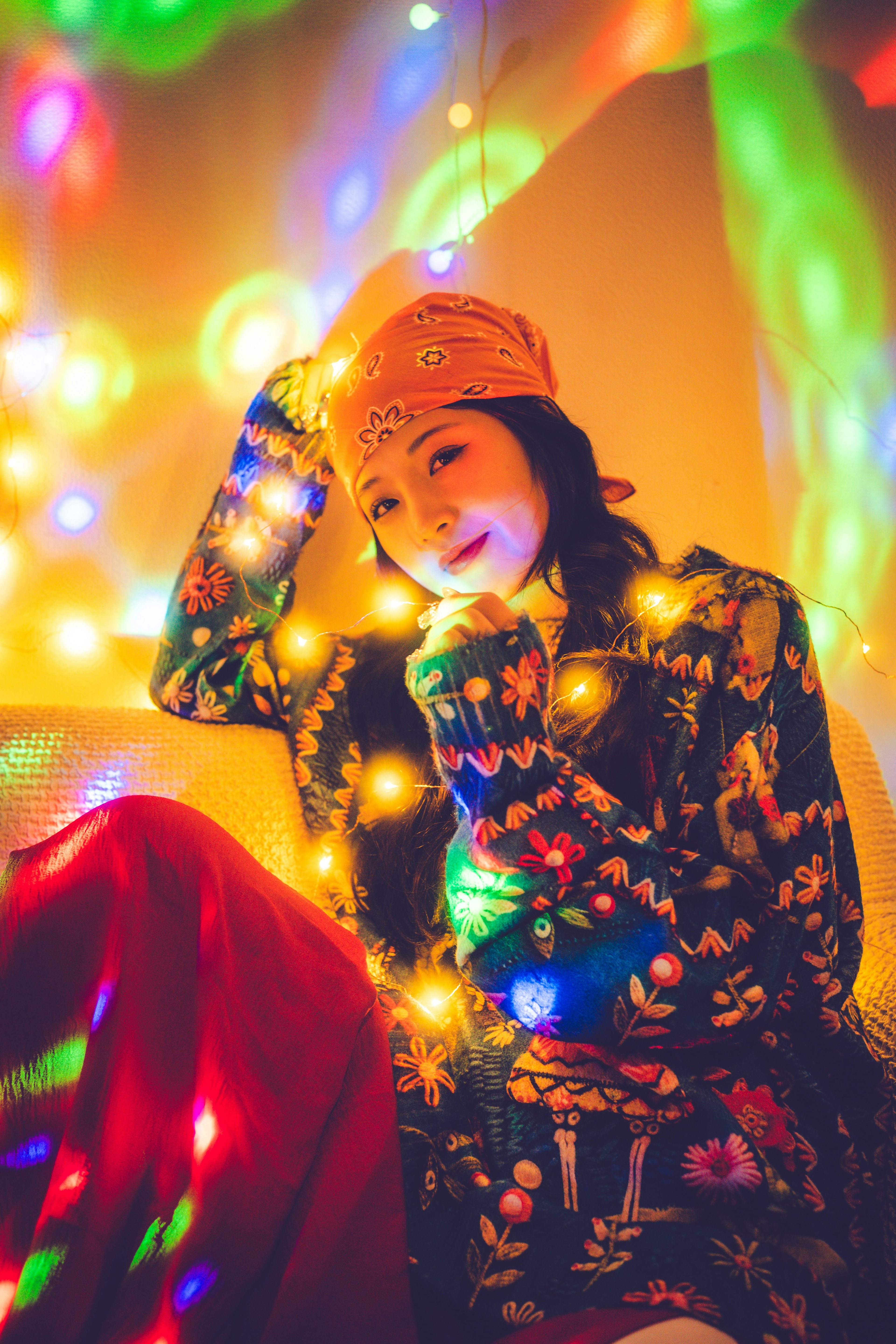 A woman posing with a smile surrounded by colorful lights