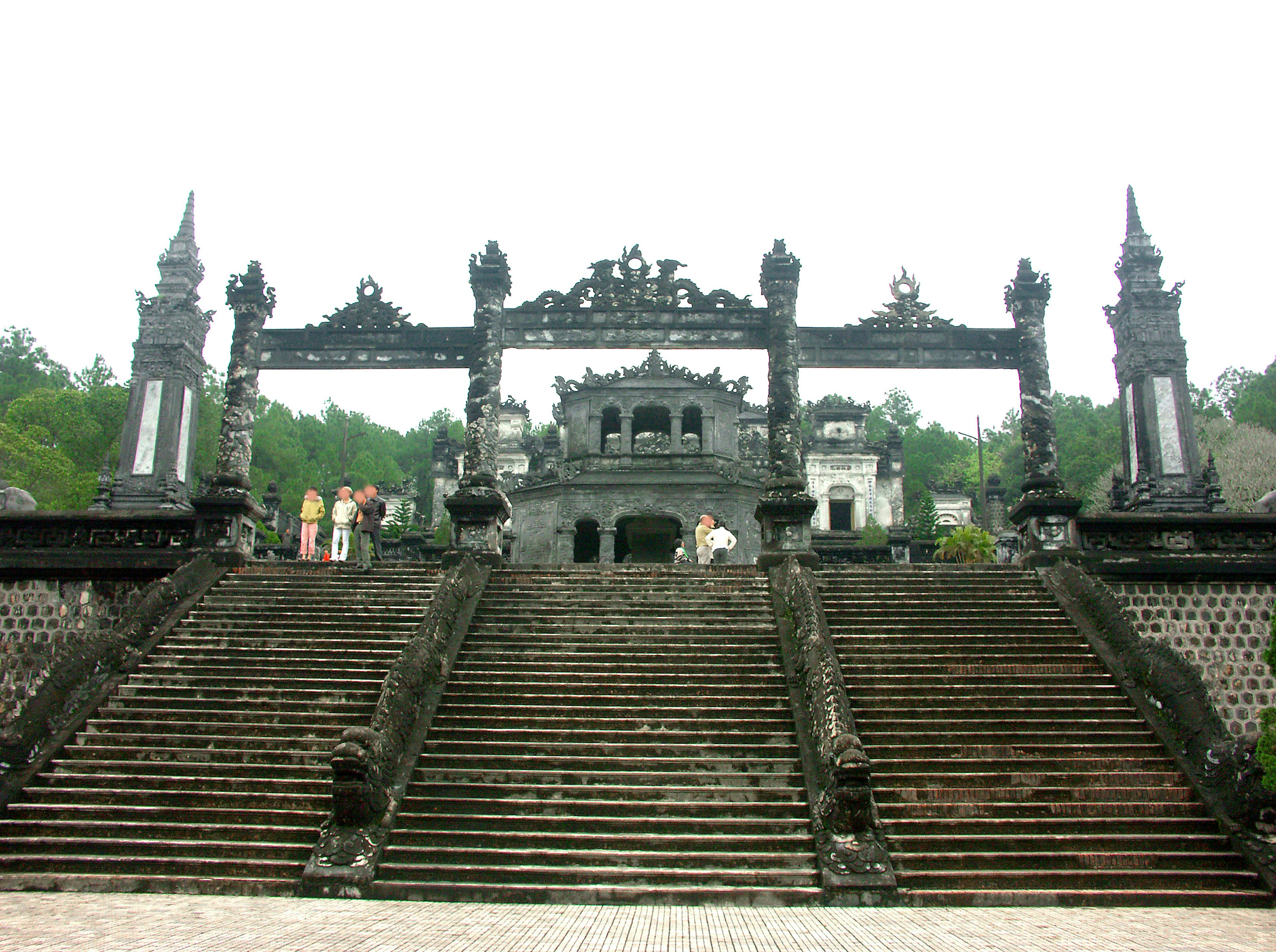 Une grande entrée avec des escaliers en pierre noire menant à un temple