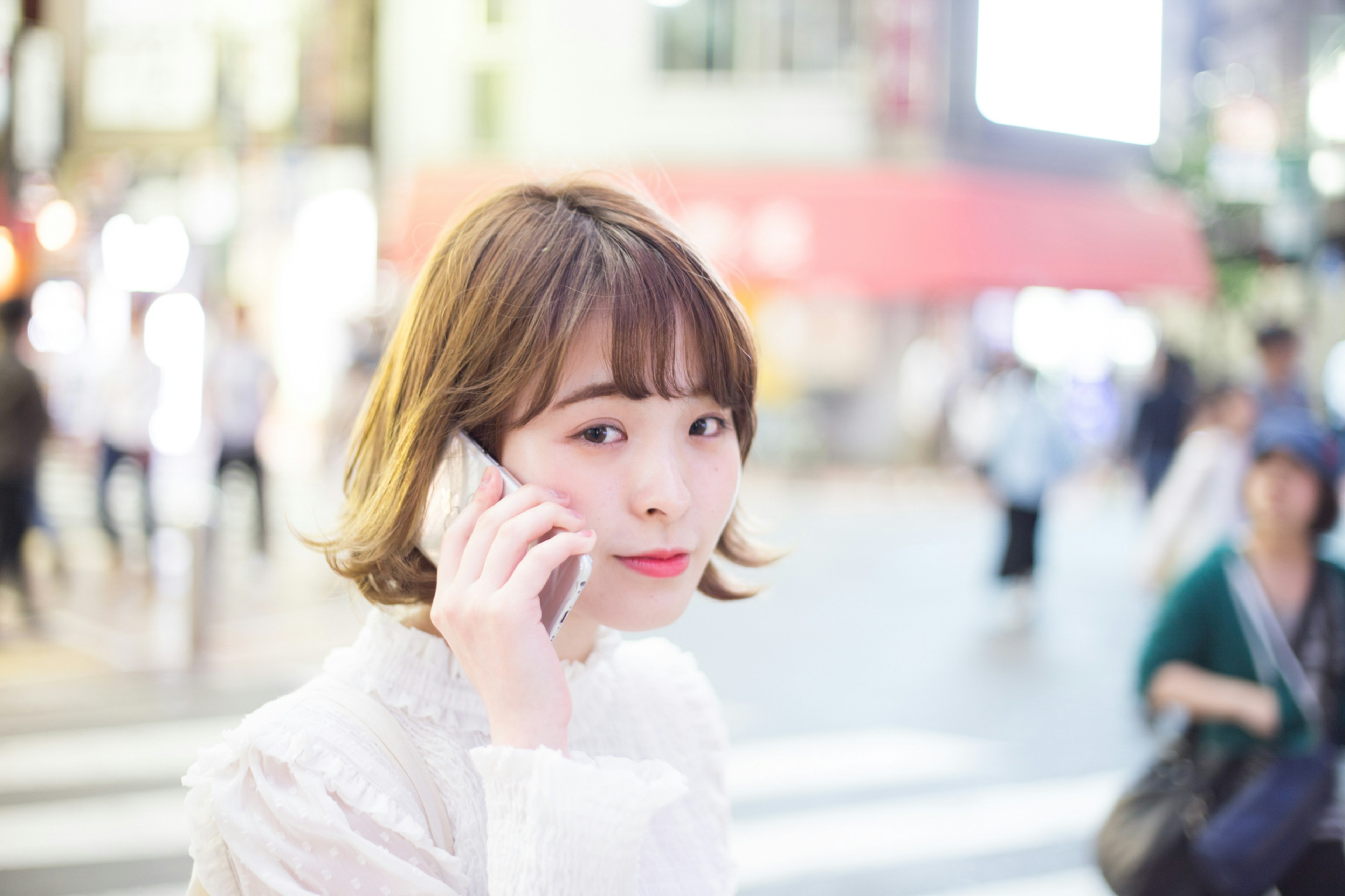 Portrait d'une femme passant un appel au téléphone à un croisement urbain arrière-plan flou