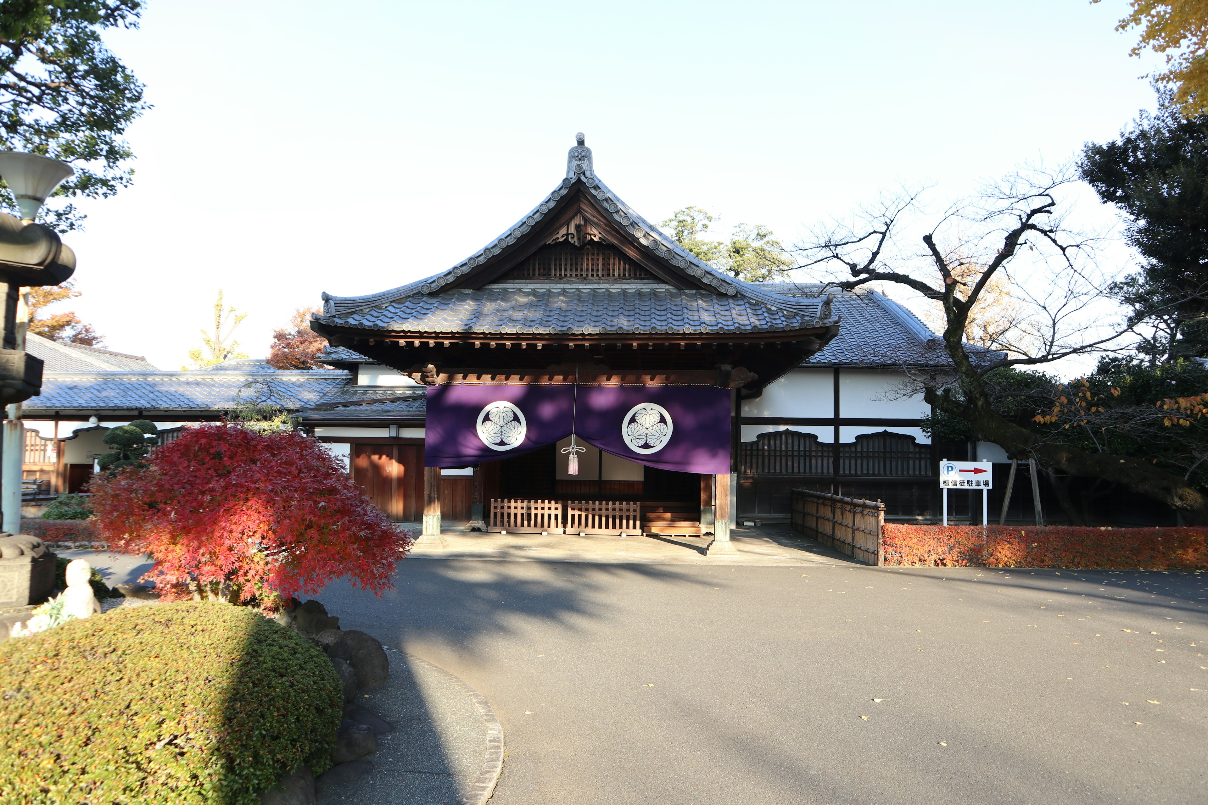 Beautiful Japanese temple gate with purple curtains and family crests