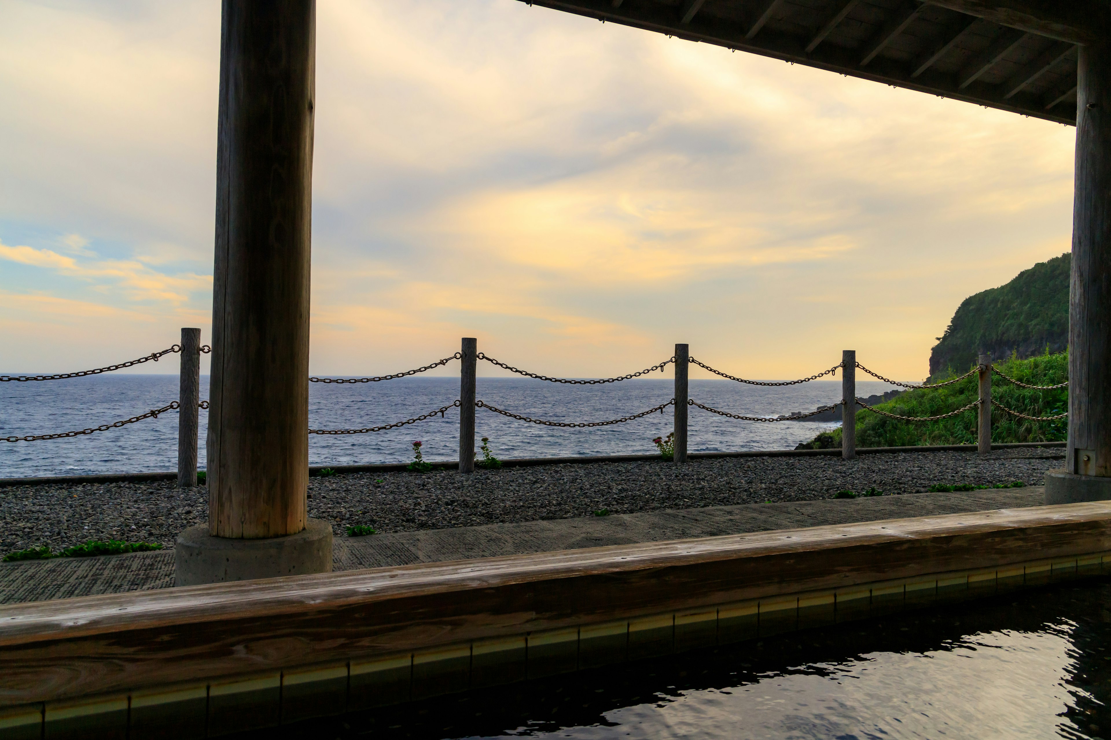 Image capturing a view of the sea and sky featuring posts and a fence along the edge