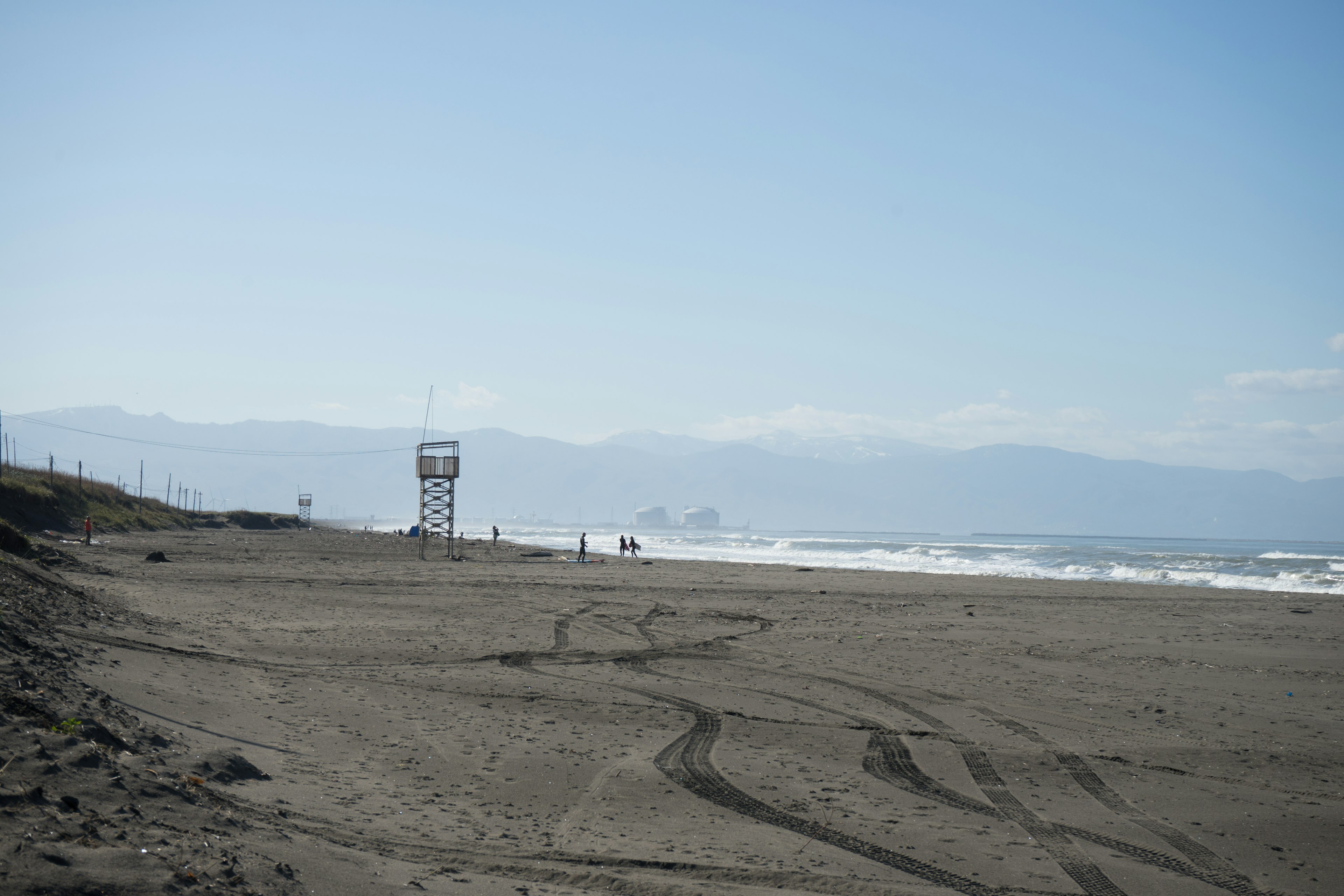 Coastal view with a lifeguard tower under a clear blue sky