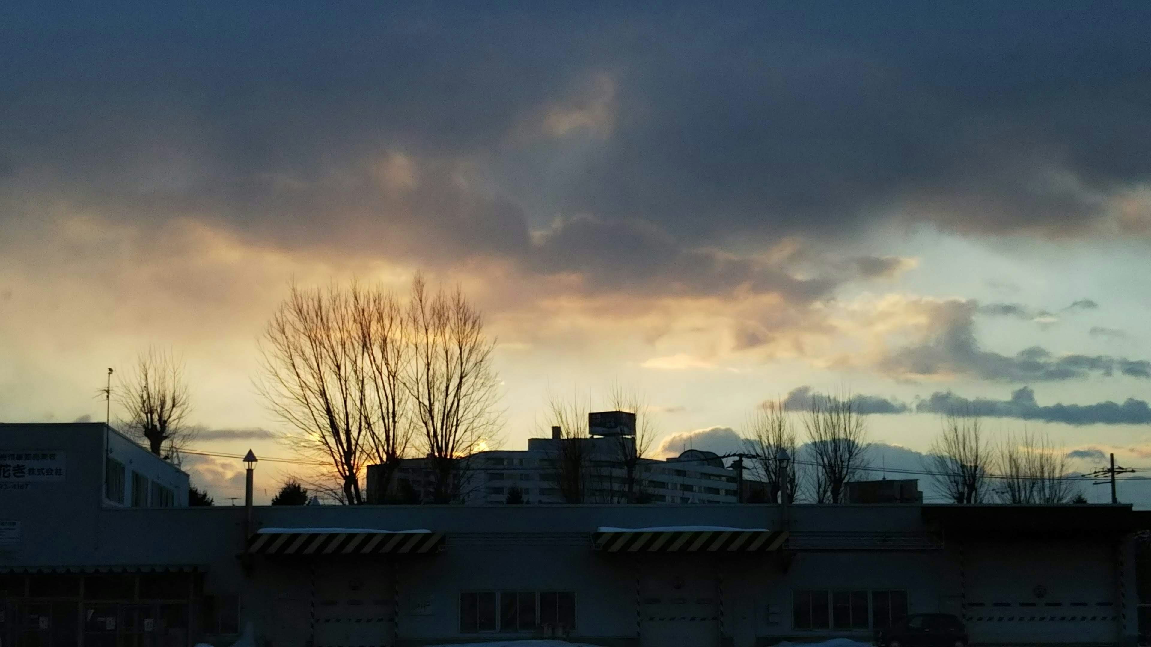 Silhouette of buildings against a sunset sky