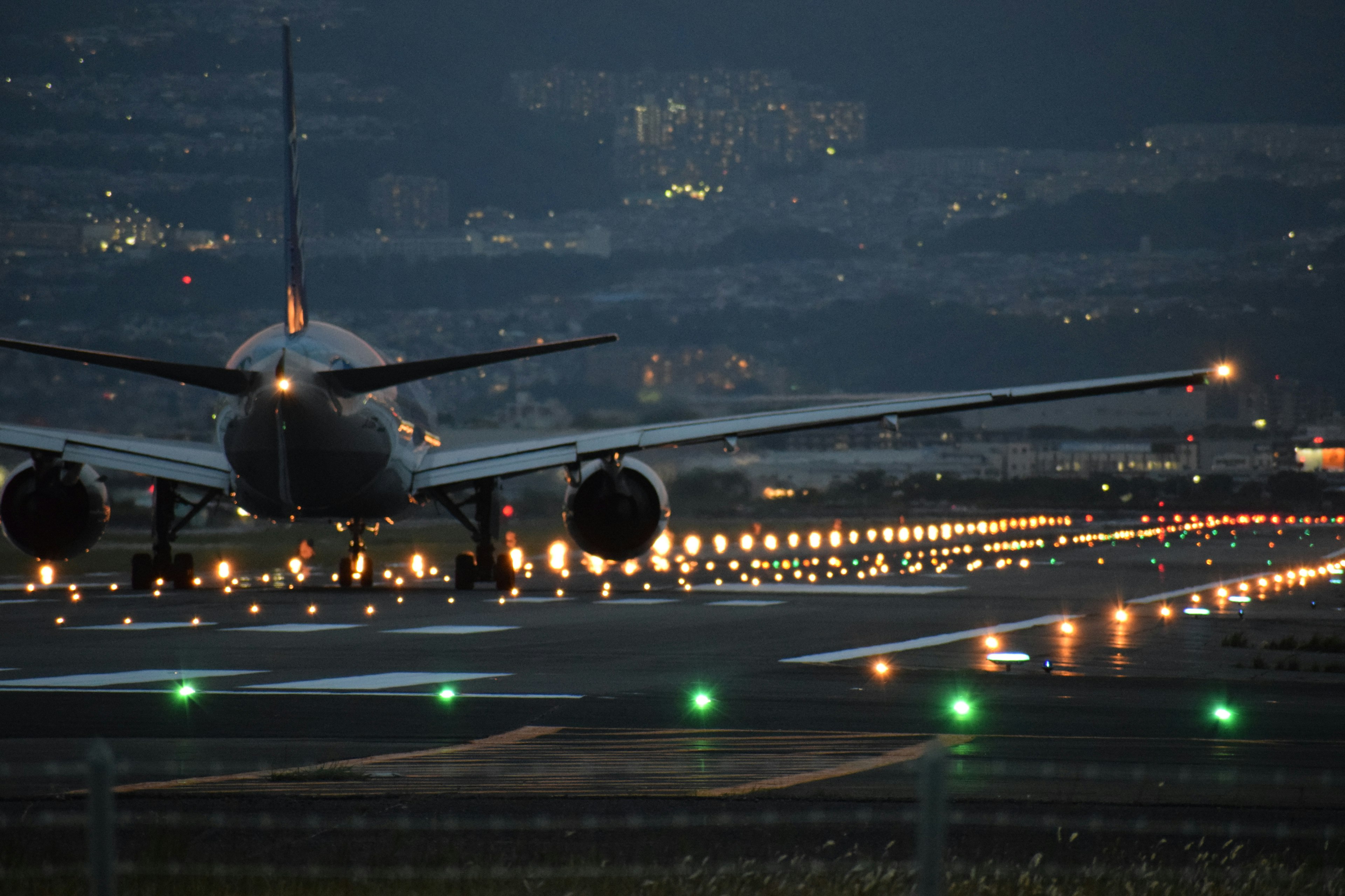 Flugzeug auf der Landebahn nachts mit beleuchteten Lichtern