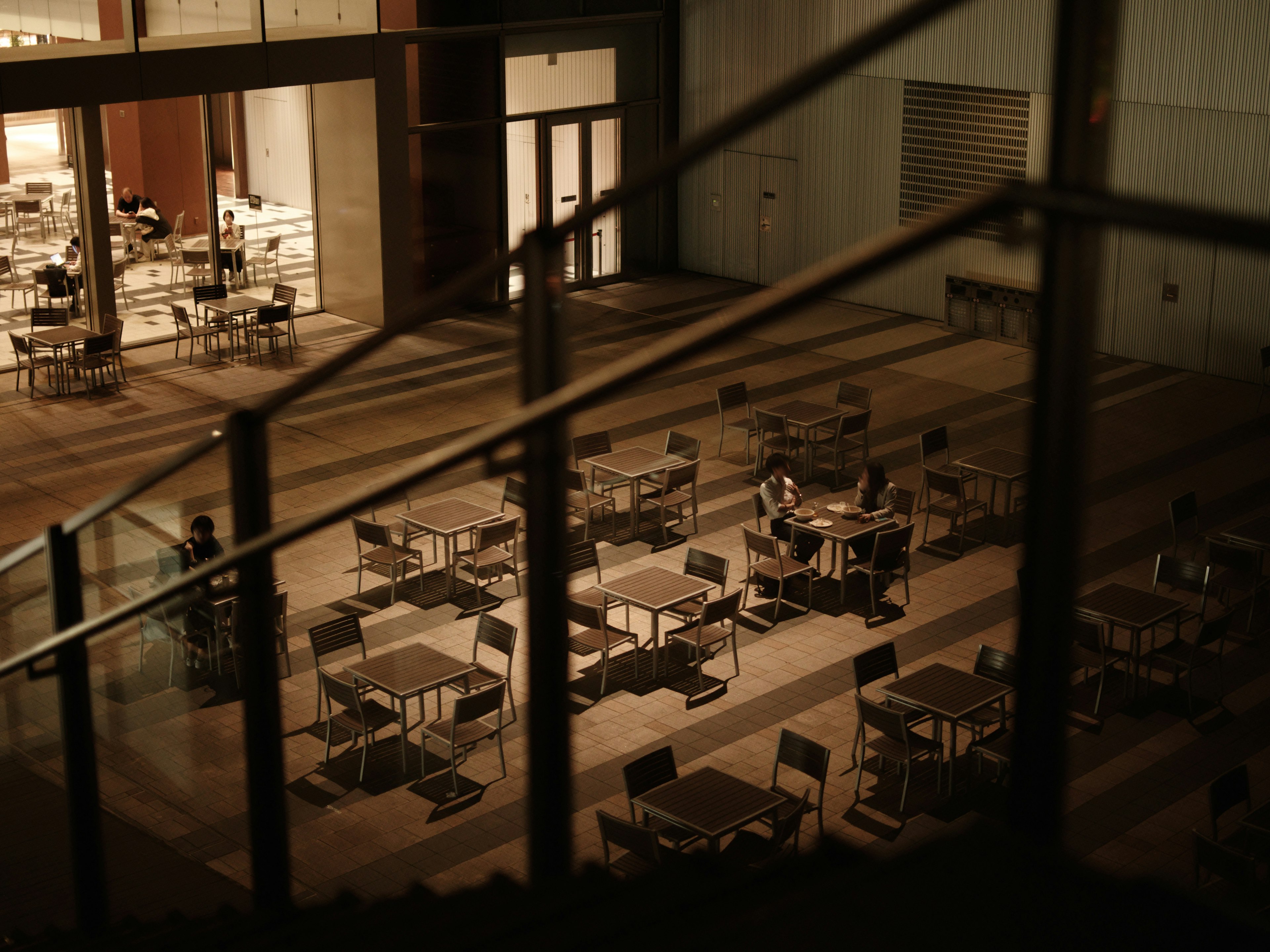 Intérieur faiblement éclairé avec des tables et des chaises disposées dans un espace calme