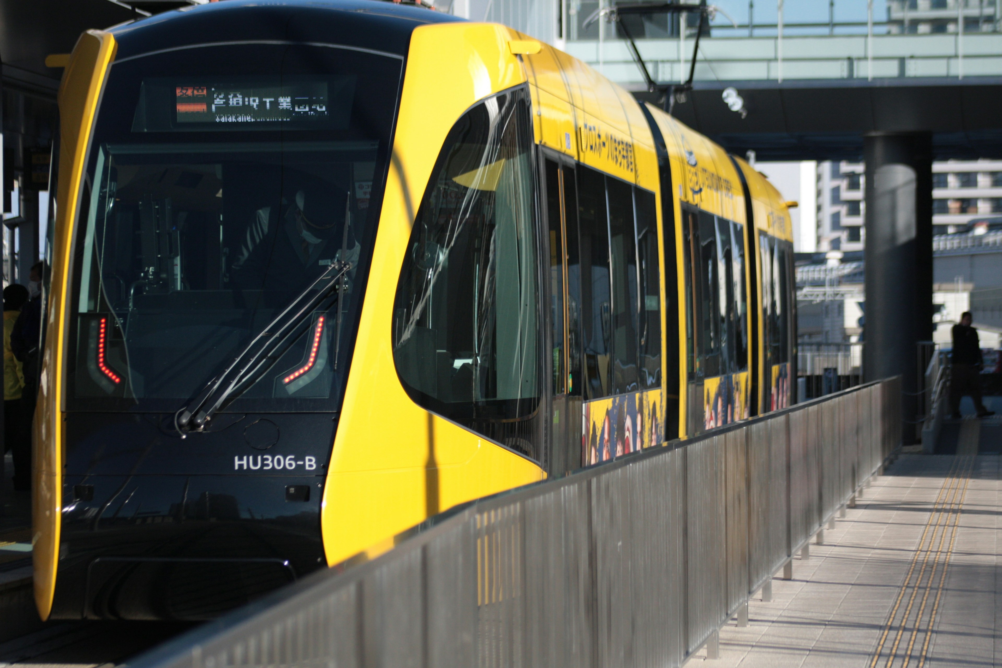 Yellow tram stopped at a station