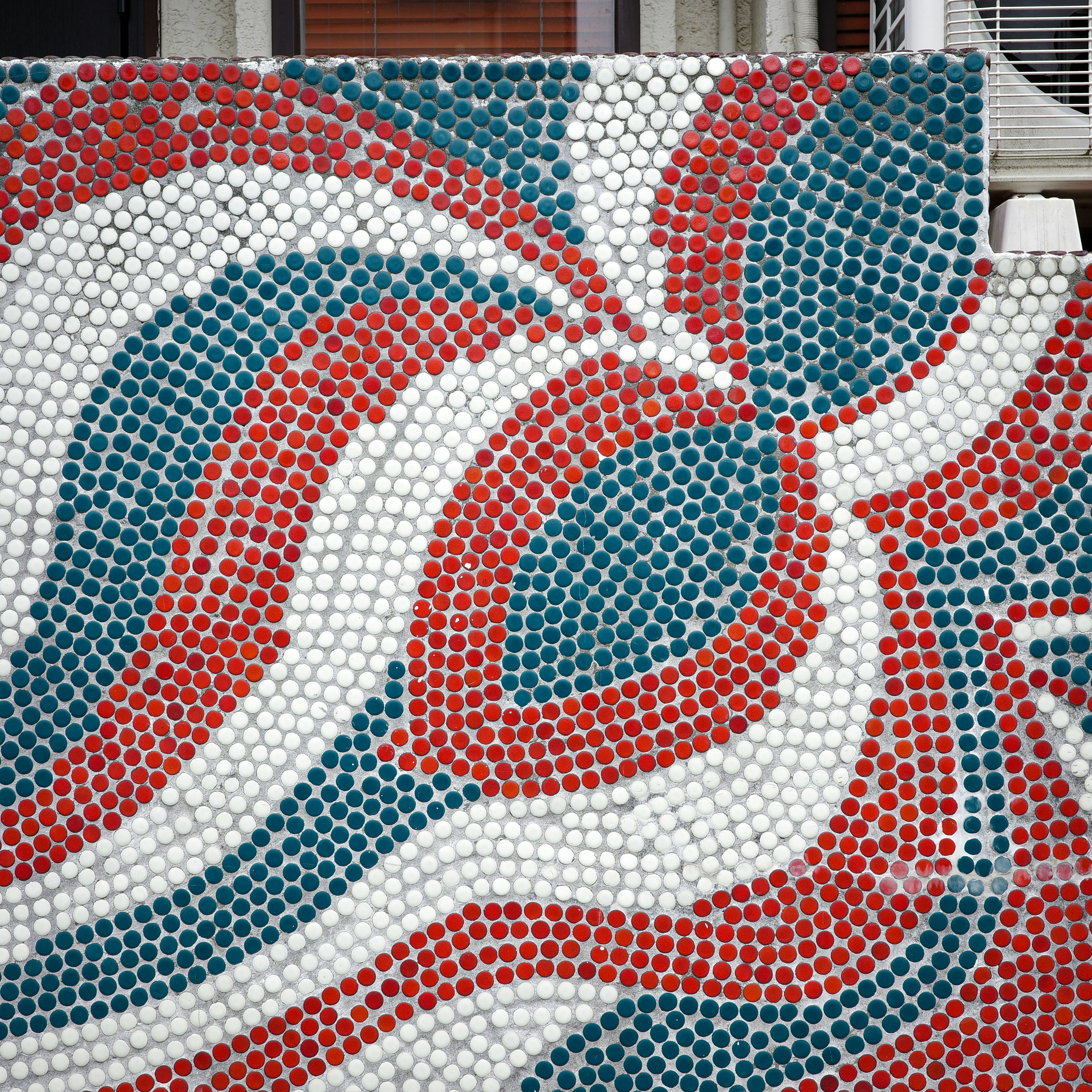 Mosaic tile design featuring red and blue wave patterns