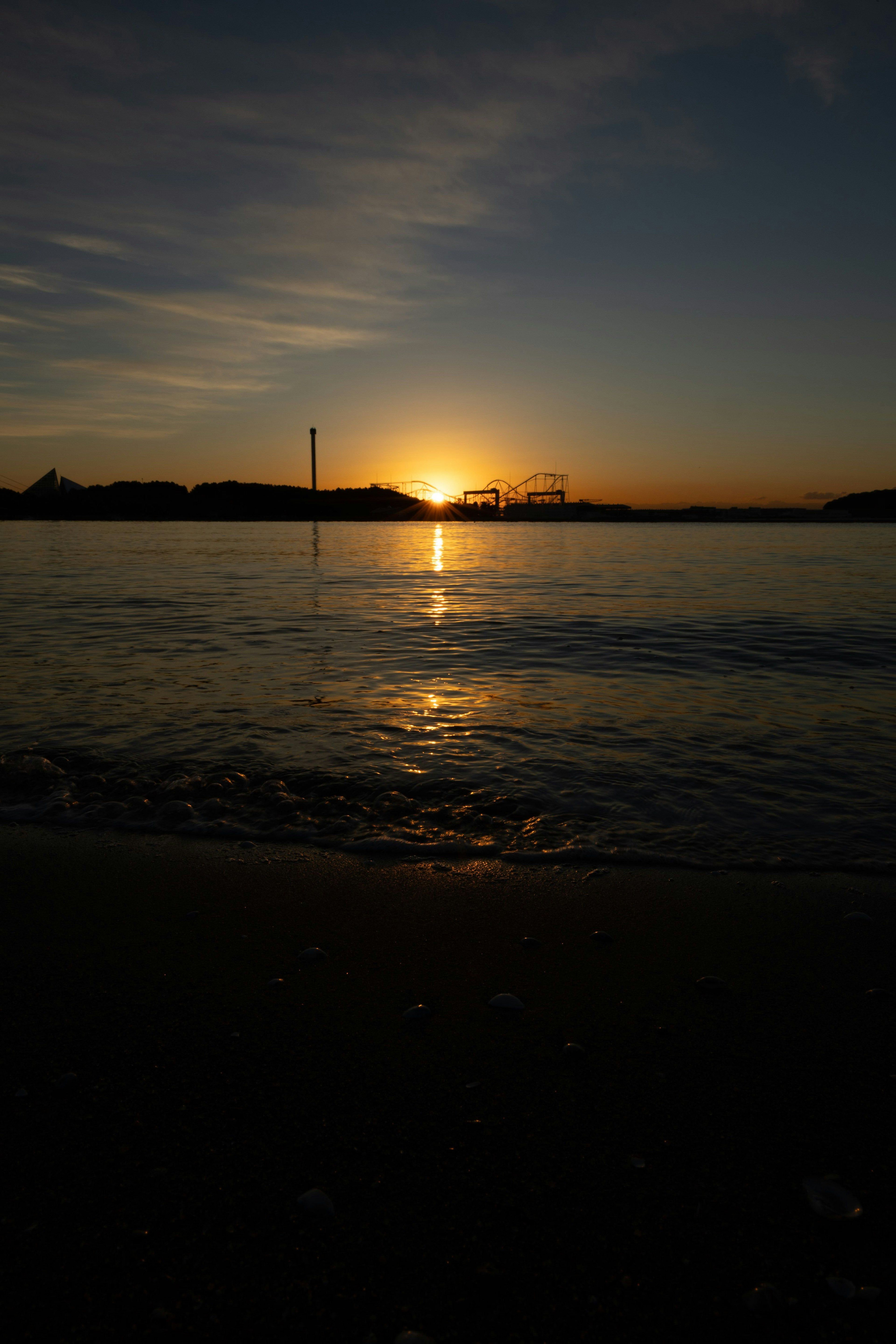 海辺の夕日が沈む風景 水面に反射するオレンジ色の光
