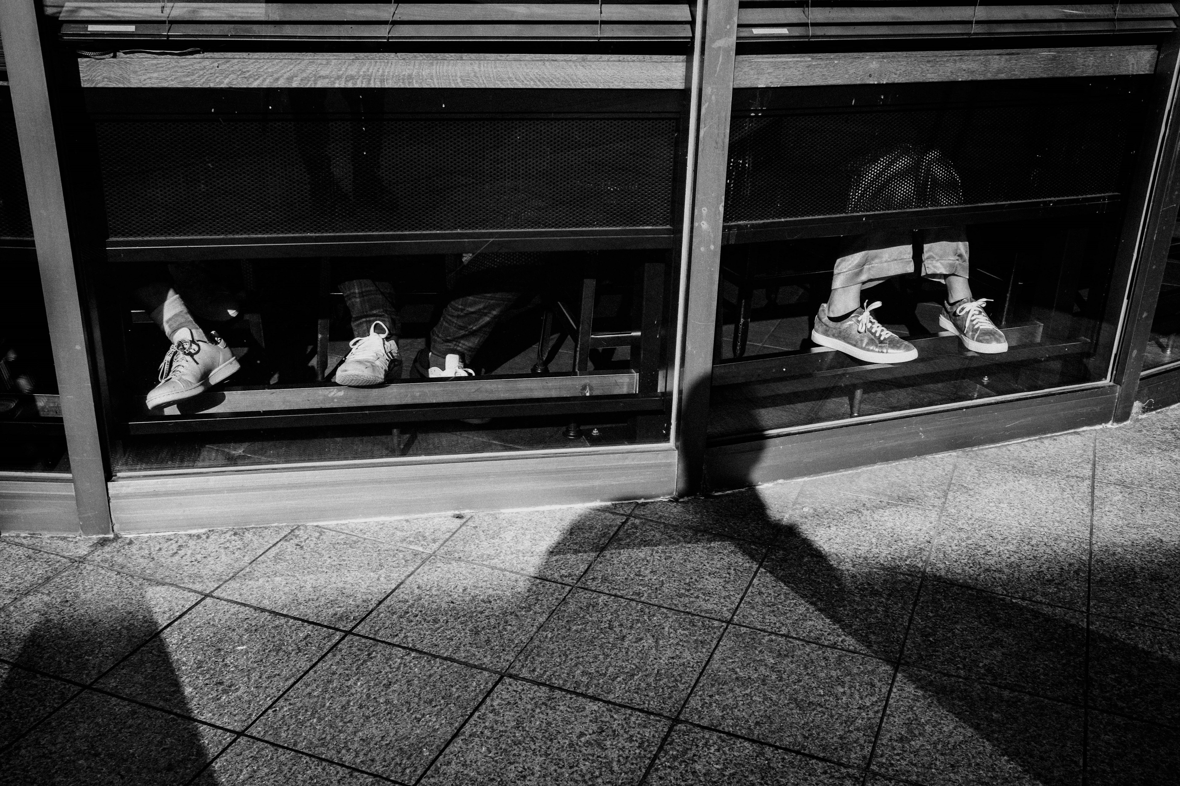 Schwarz-Weiß-Foto von Menschen, die an einem Fenster sitzen