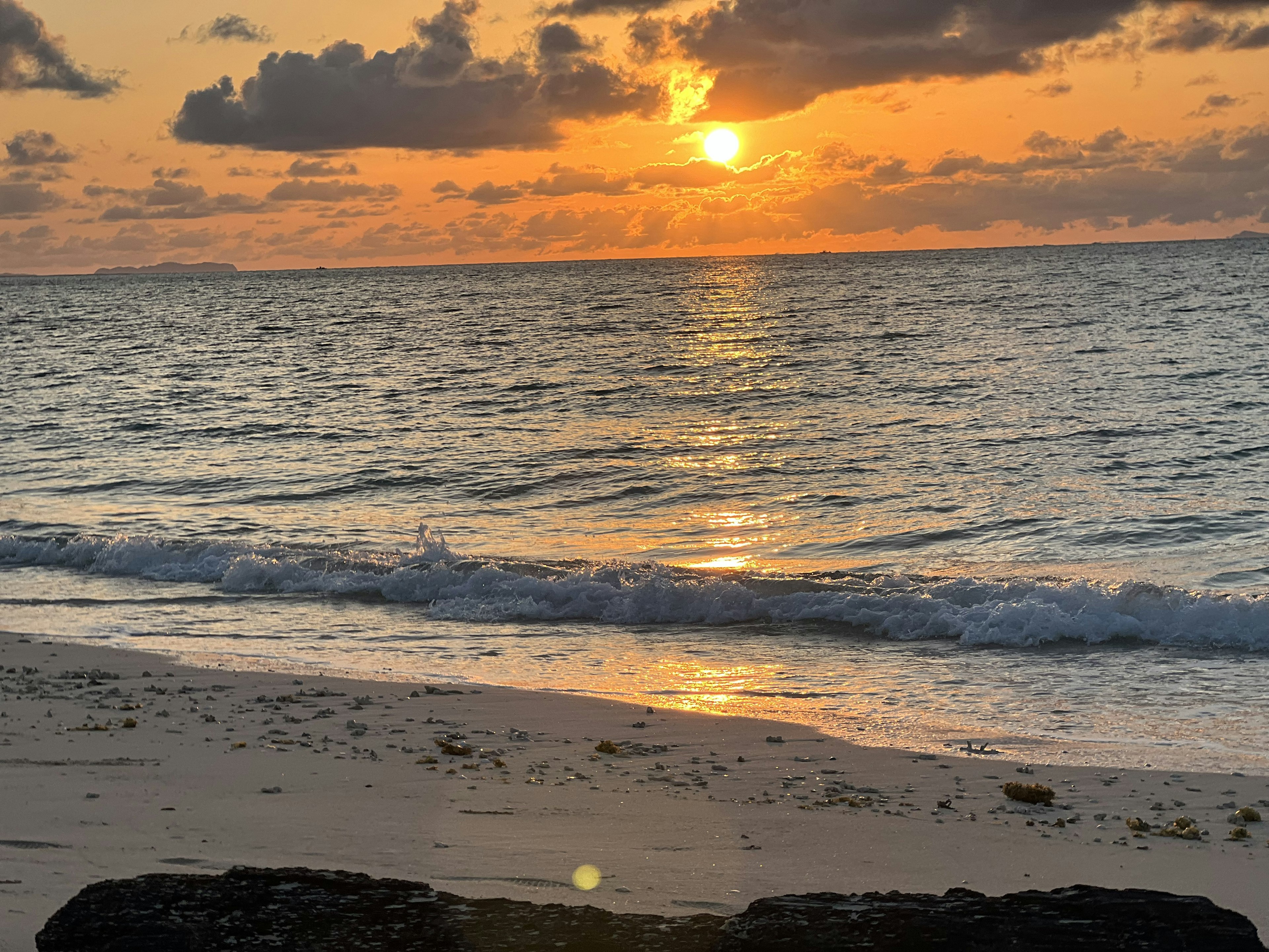 Bellissimo panorama di spiaggia con il sole che tramonta sul mare