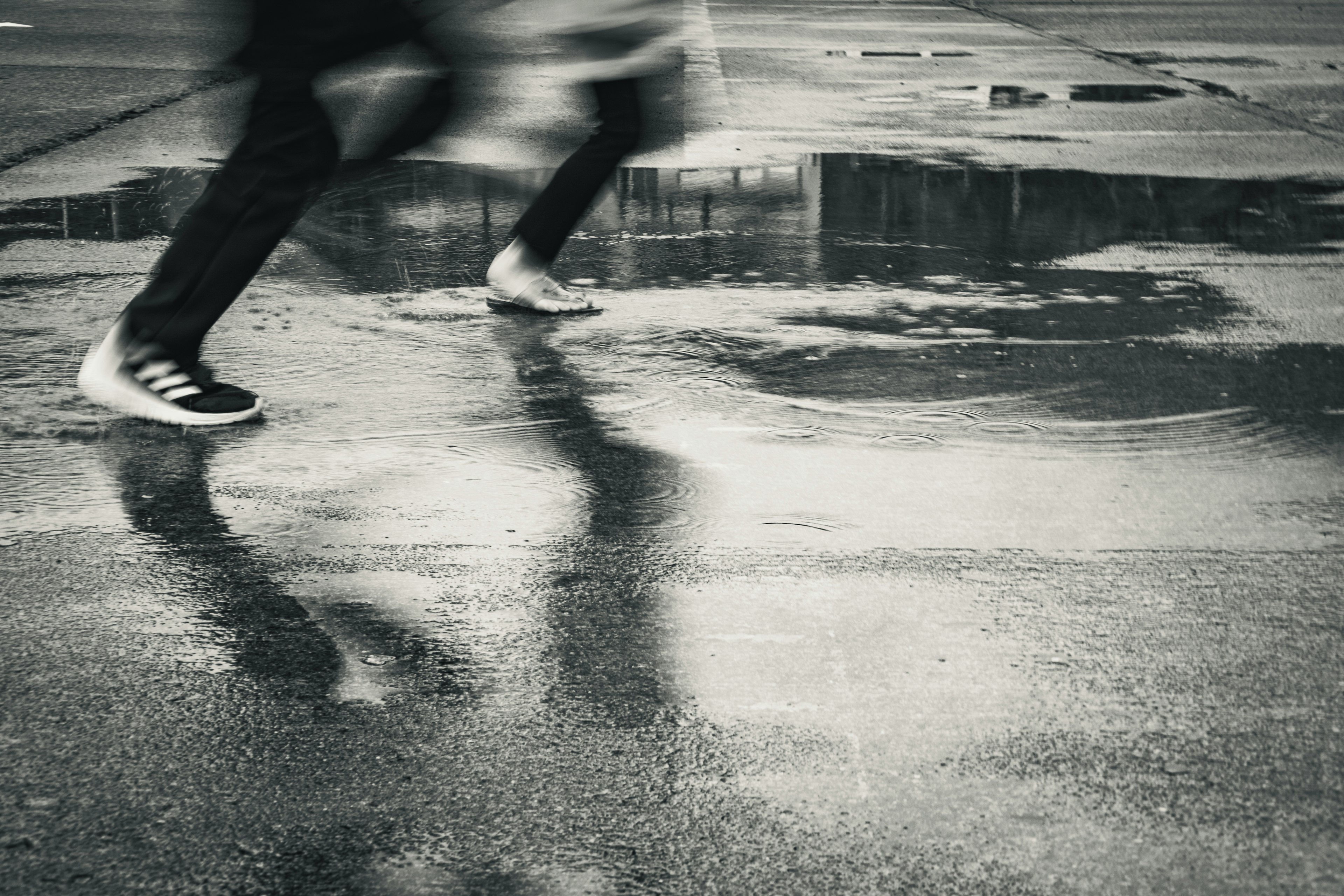 Blurred image of feet running on a wet surface after rain