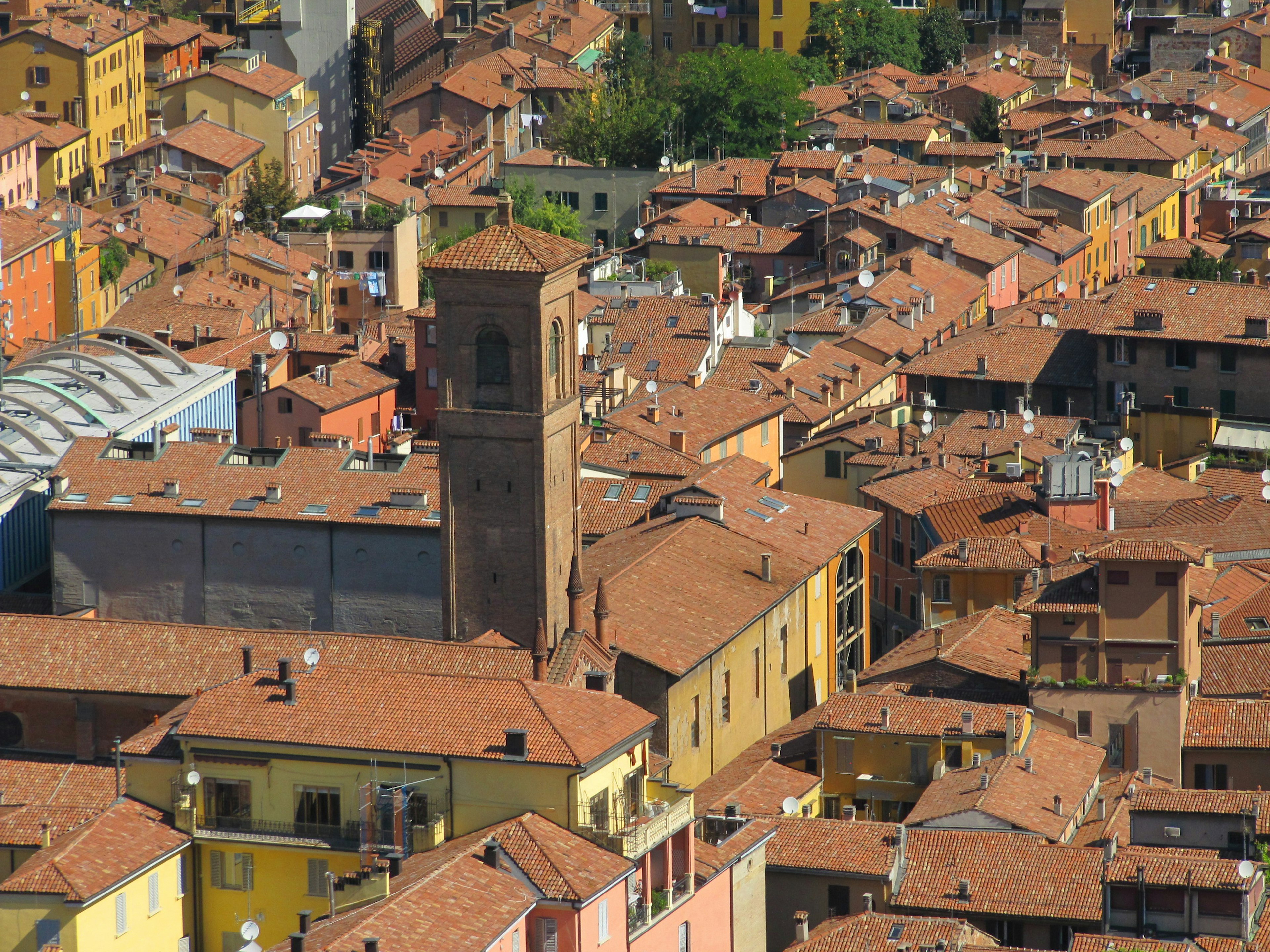 Aerial view of Bologna showcasing terracotta rooftops and colorful buildings