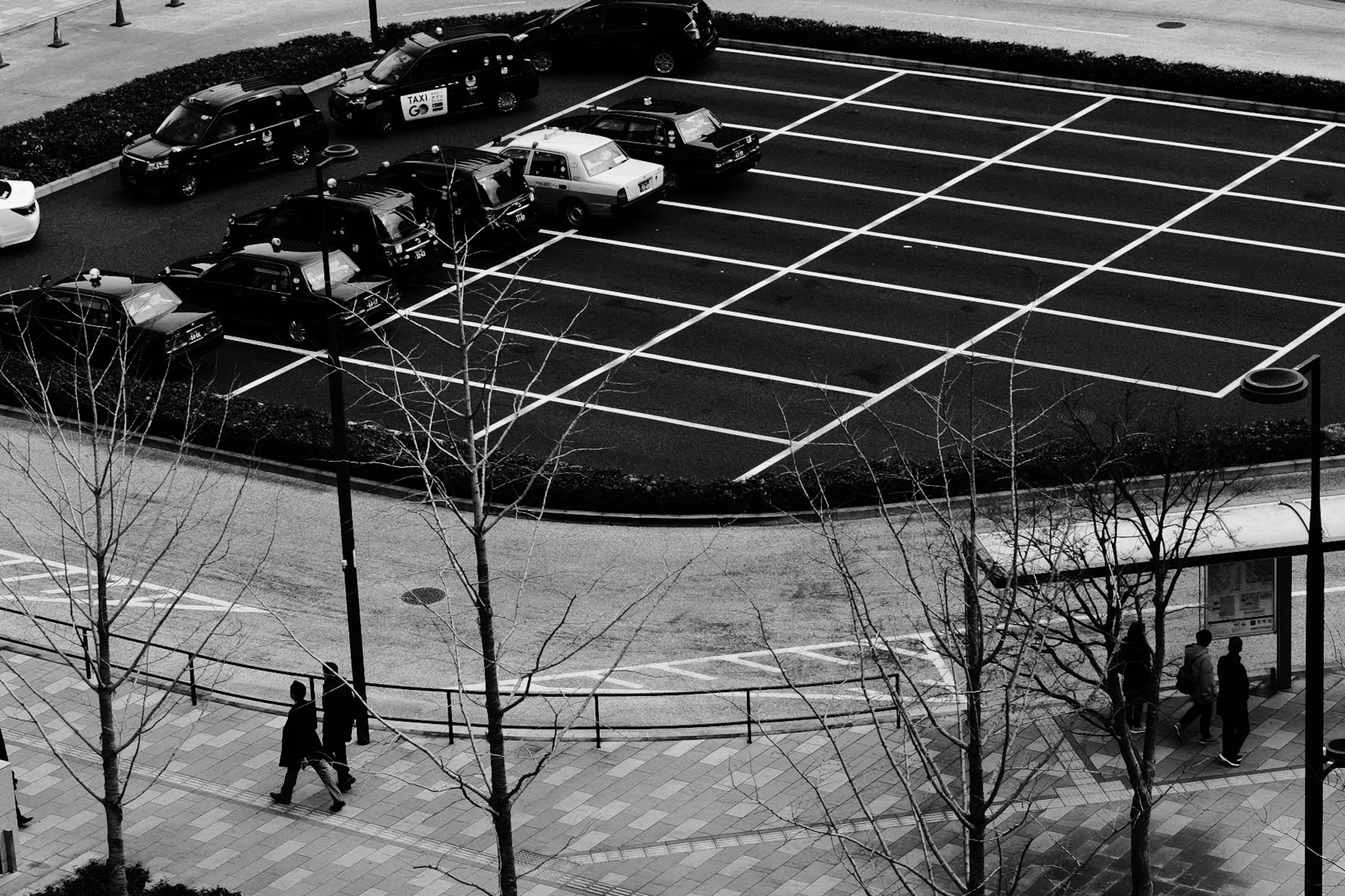 Vue en noir et blanc d'un parking avec des piétons