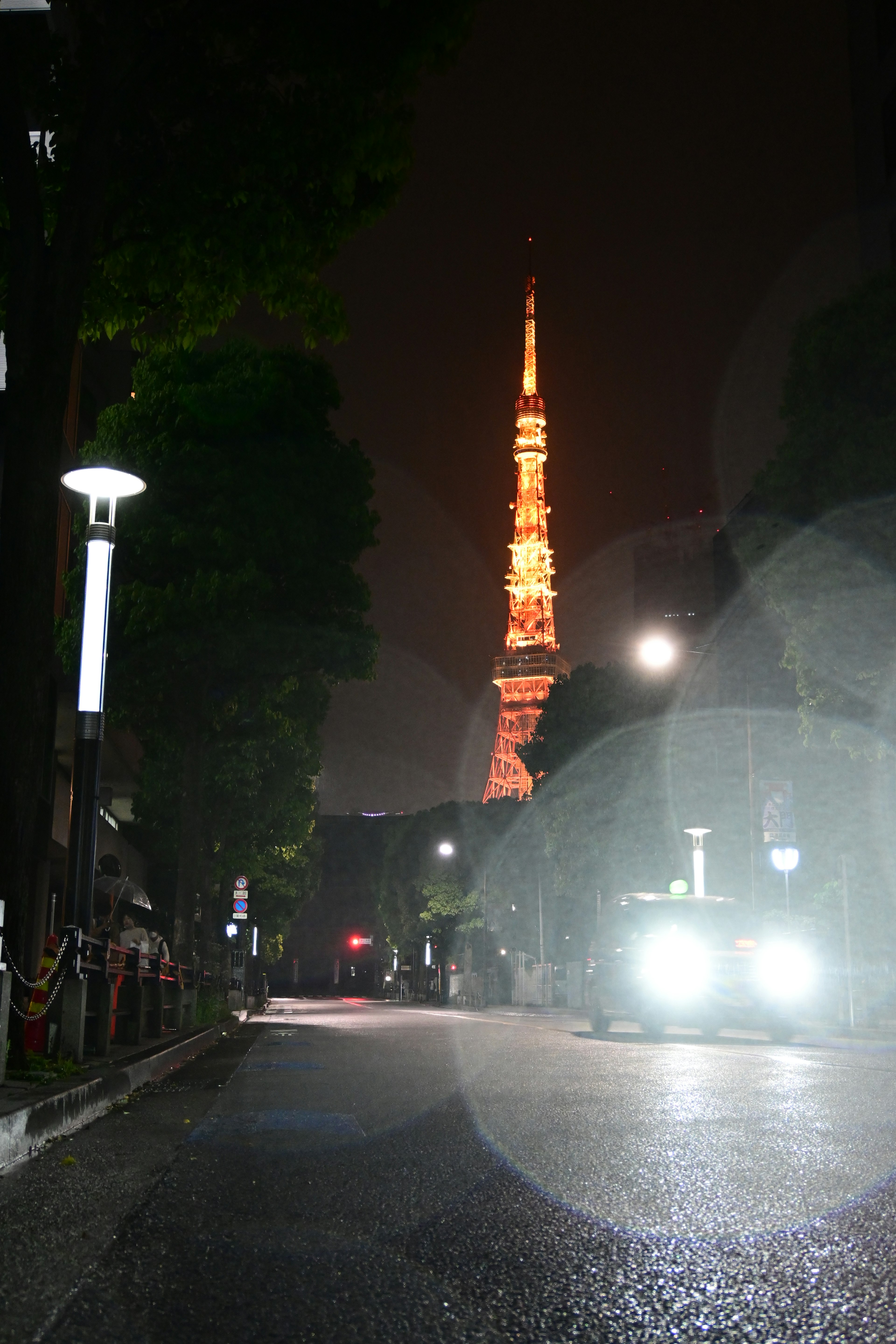 Torre de Tokio iluminada de noche con una calle poco iluminada