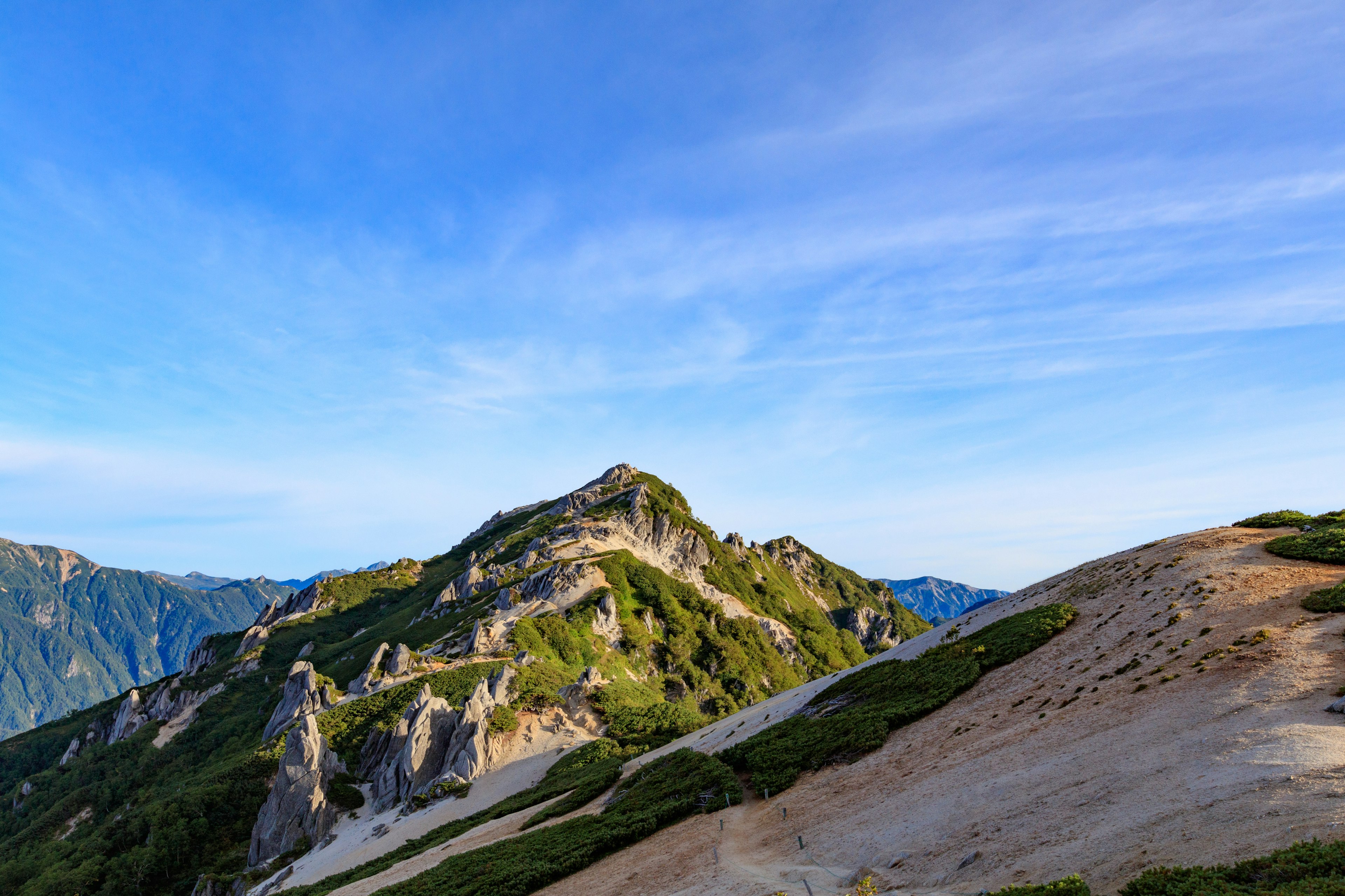 Gunung dan bukit hijau di bawah langit biru