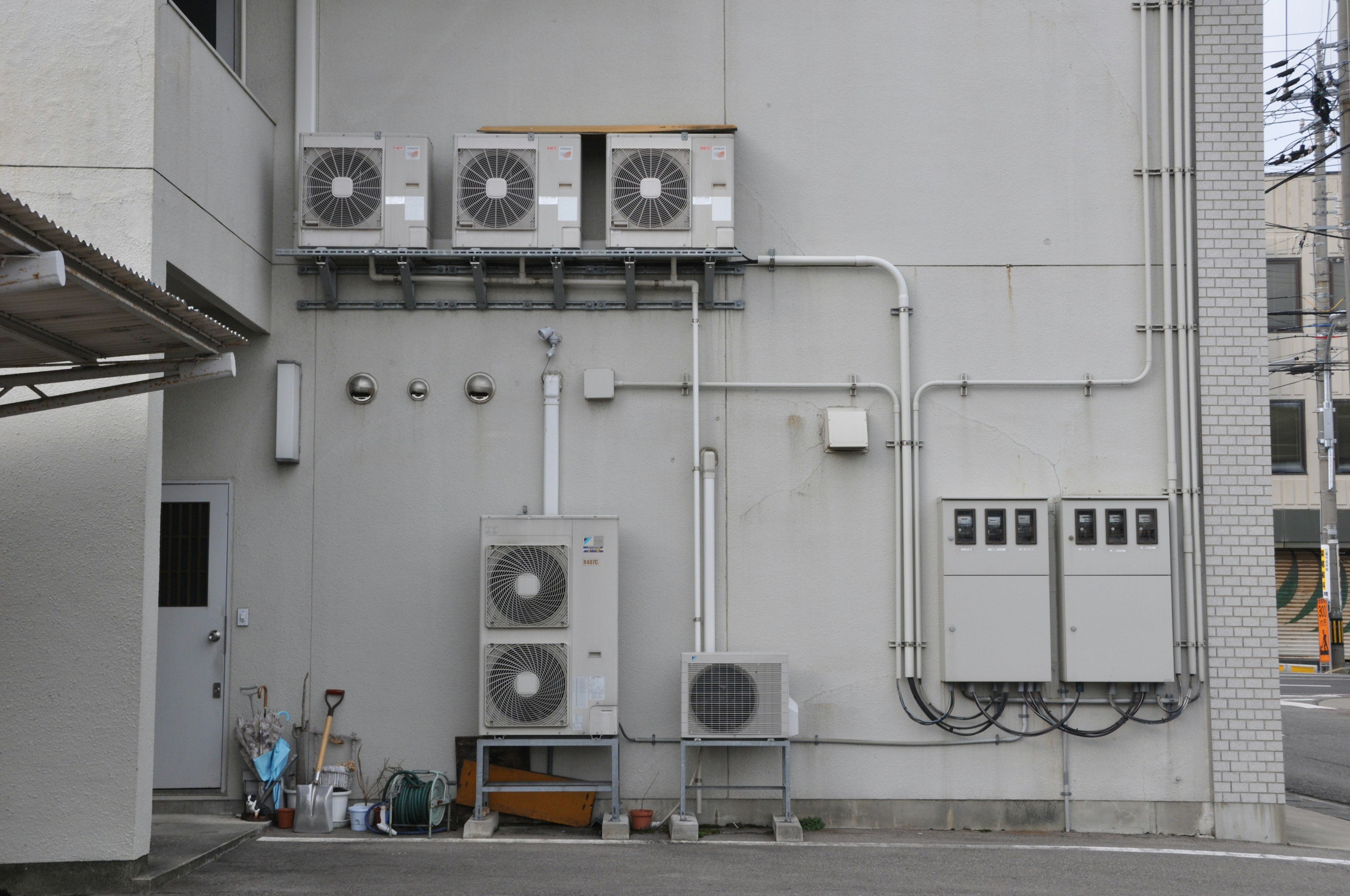 建物の外壁に取り付けられたエアコンユニットと配管が見える