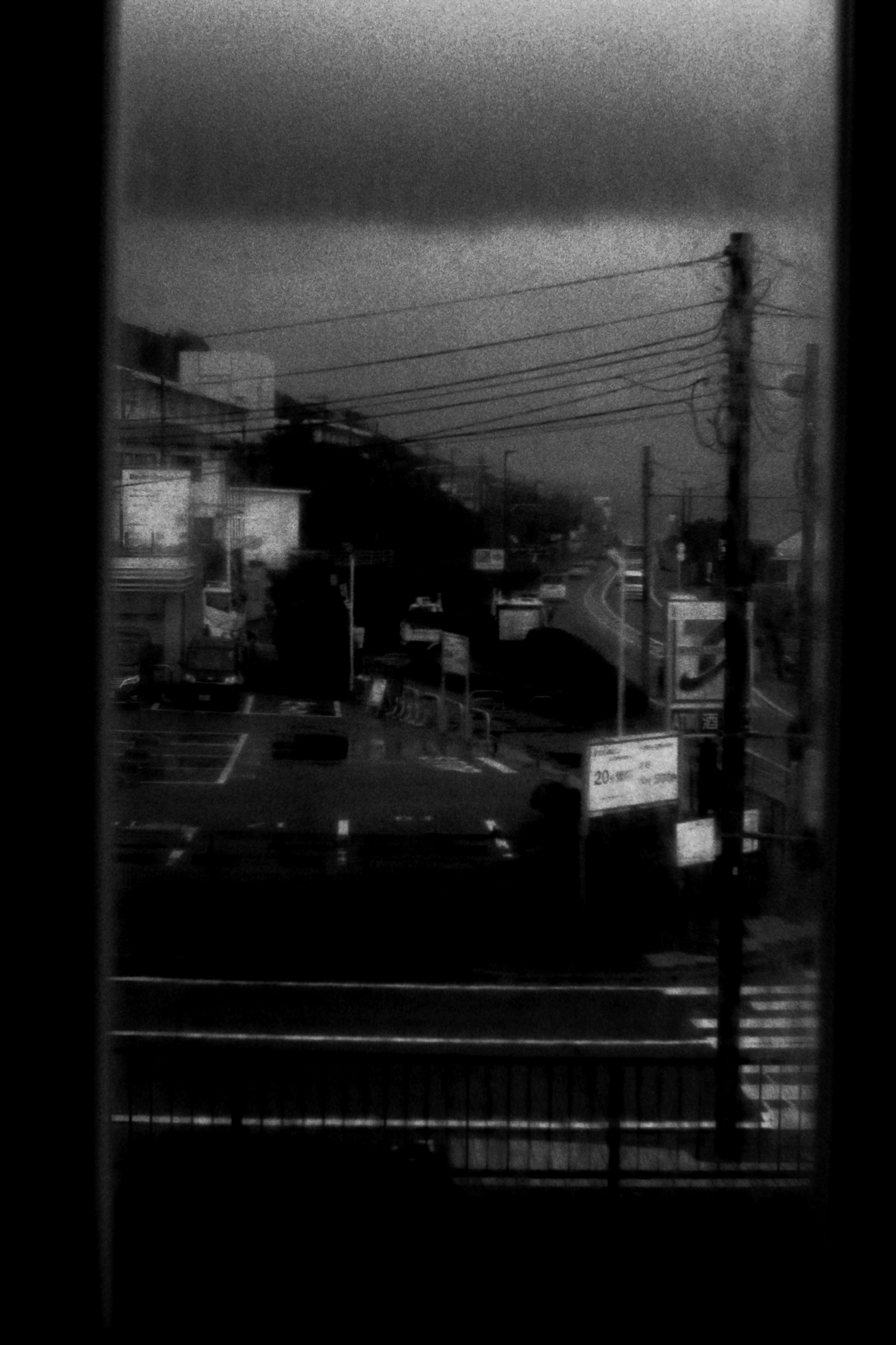 Urban landscape under dark clouds featuring roads and power lines