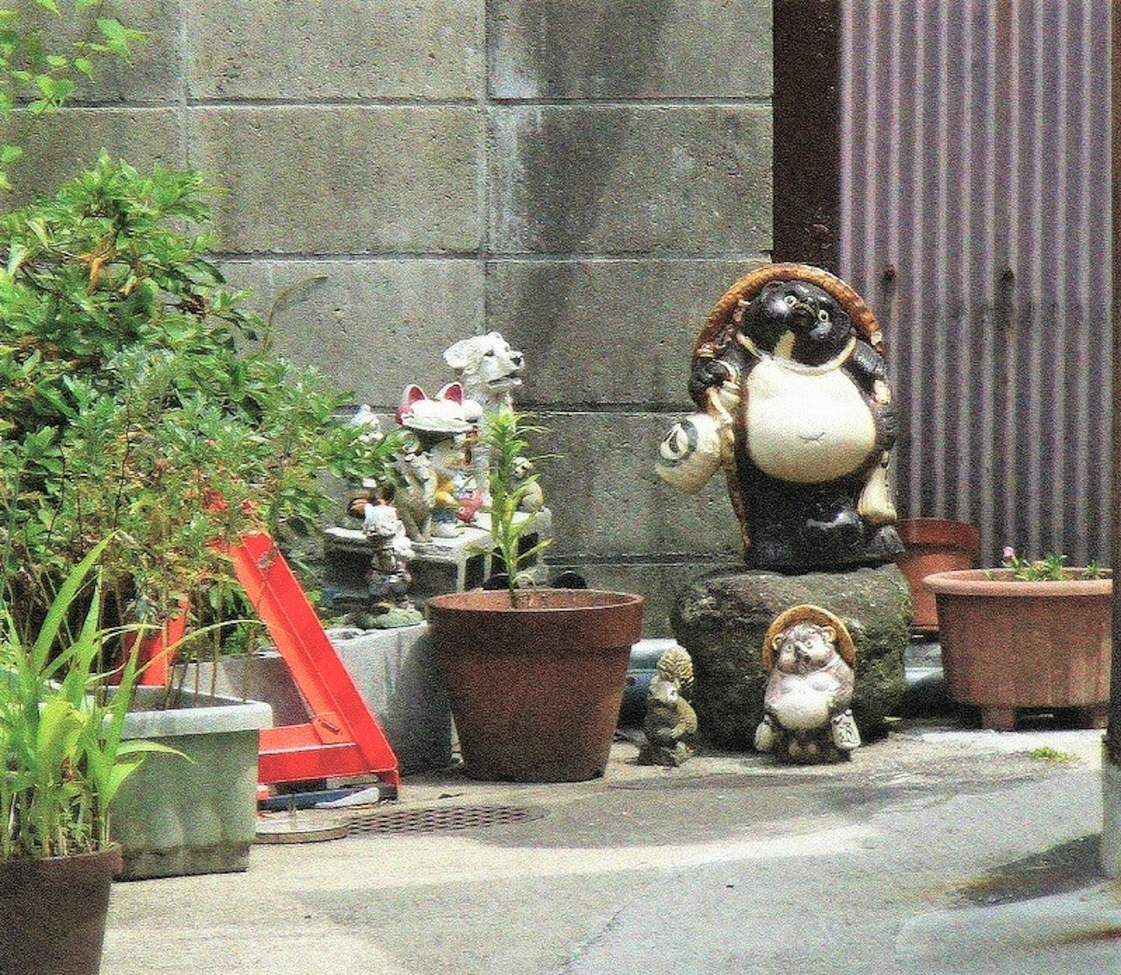 Una escena de figuritas de cerámica y macetas en un jardín