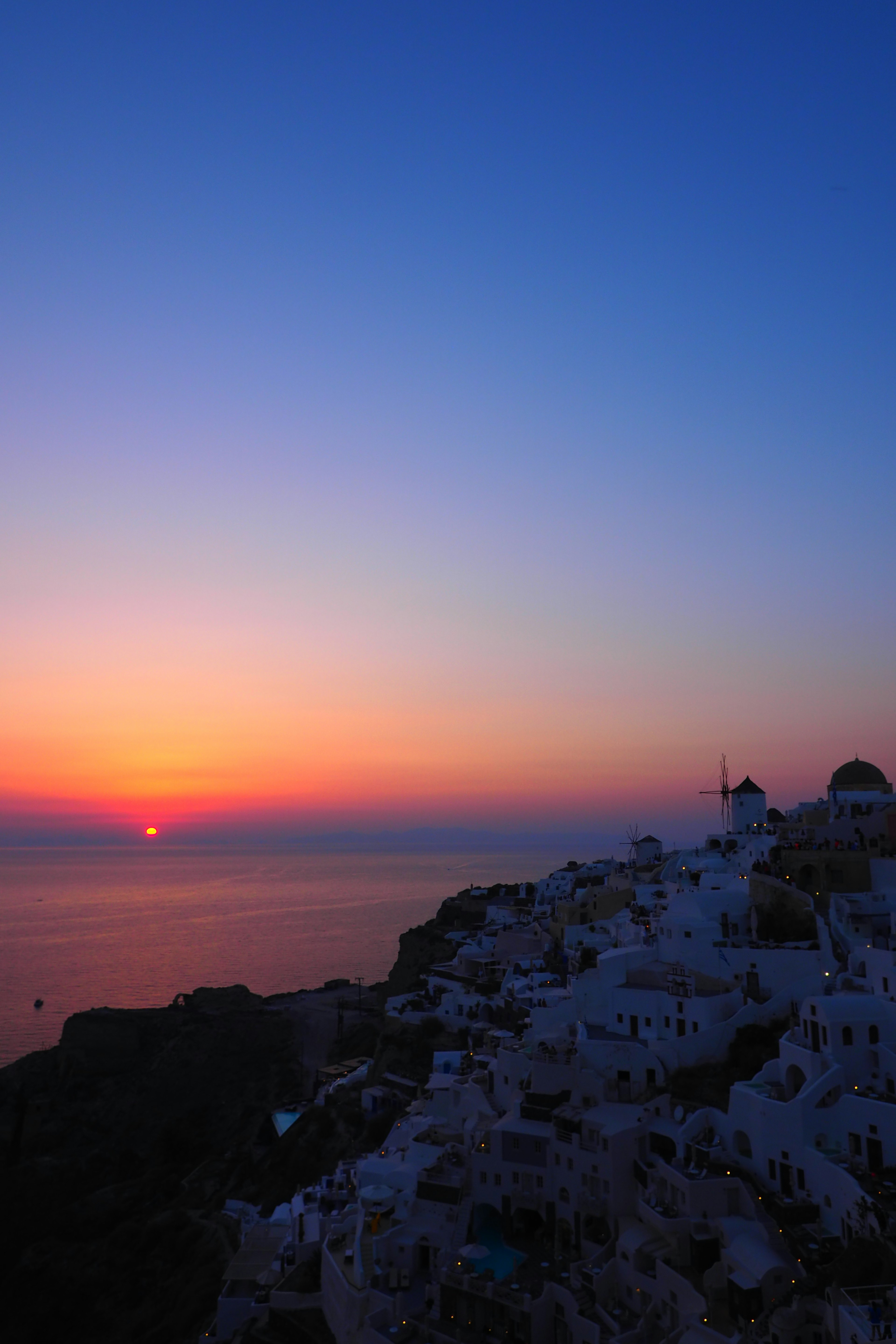 Coucher de soleil magnifique sur la mer avec des bâtiments blancs à Santorin