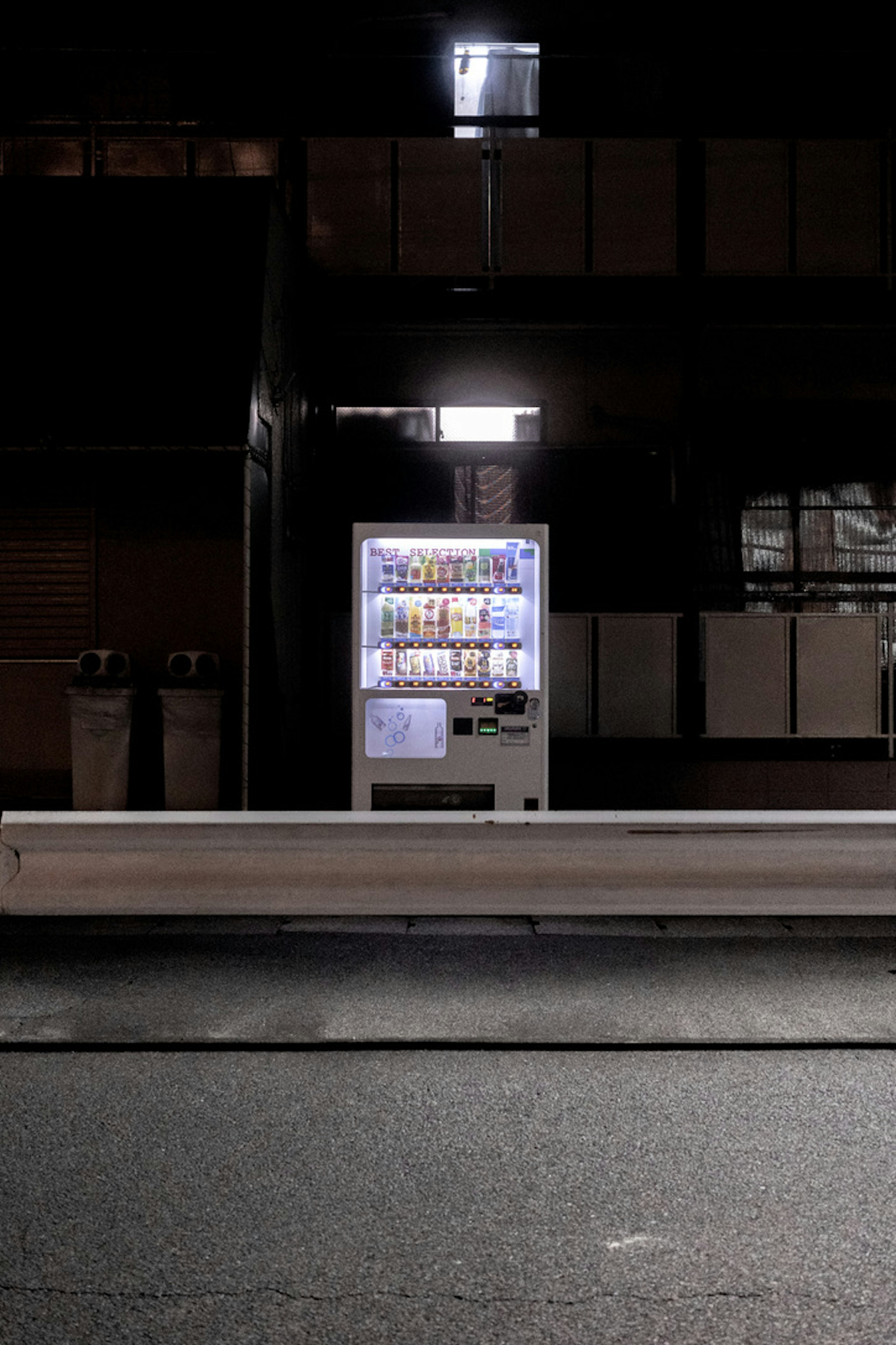 A vending machine illuminated at night in an urban setting