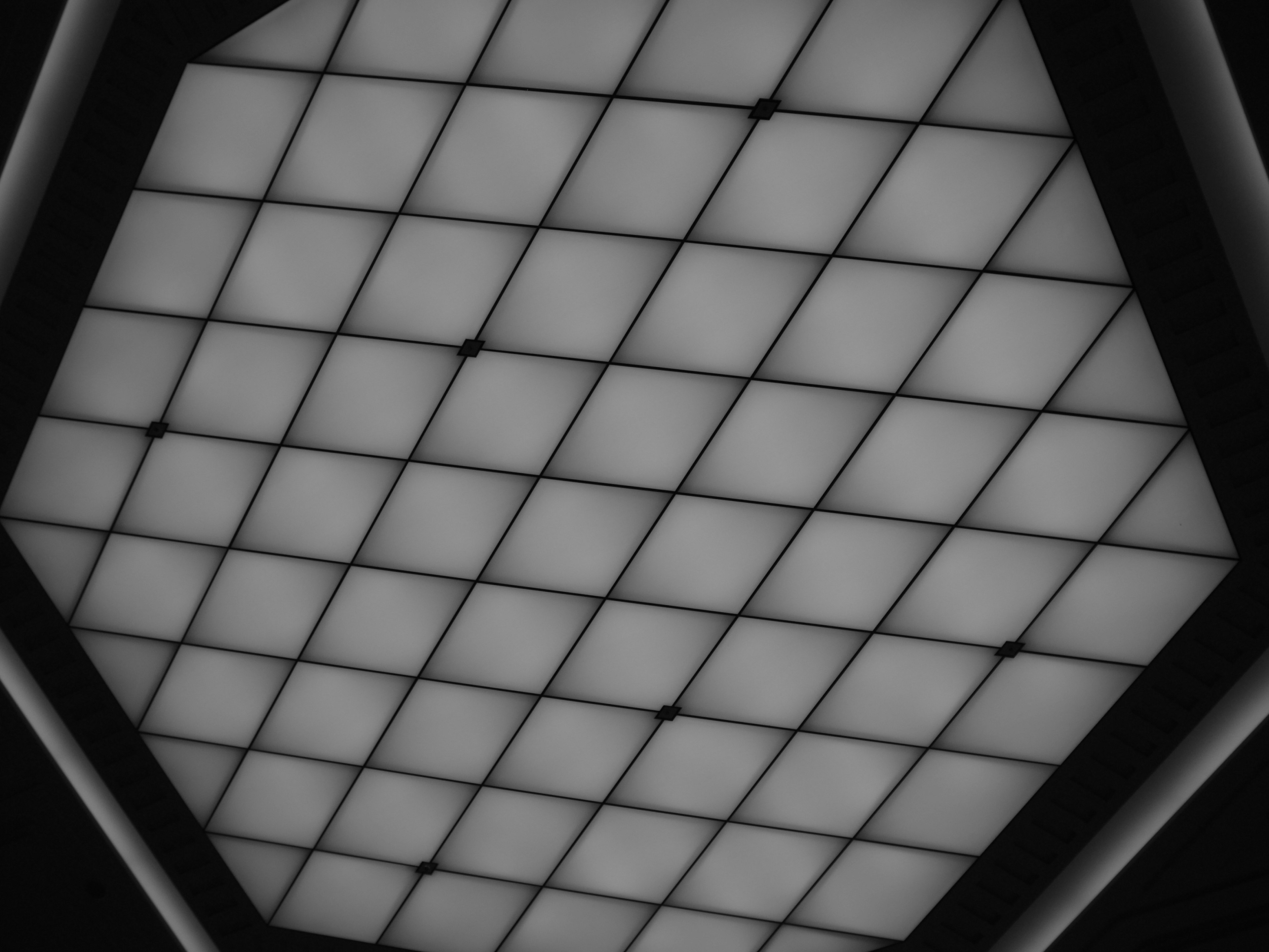 Hexagonal ceiling with bright square lights arranged in a grid