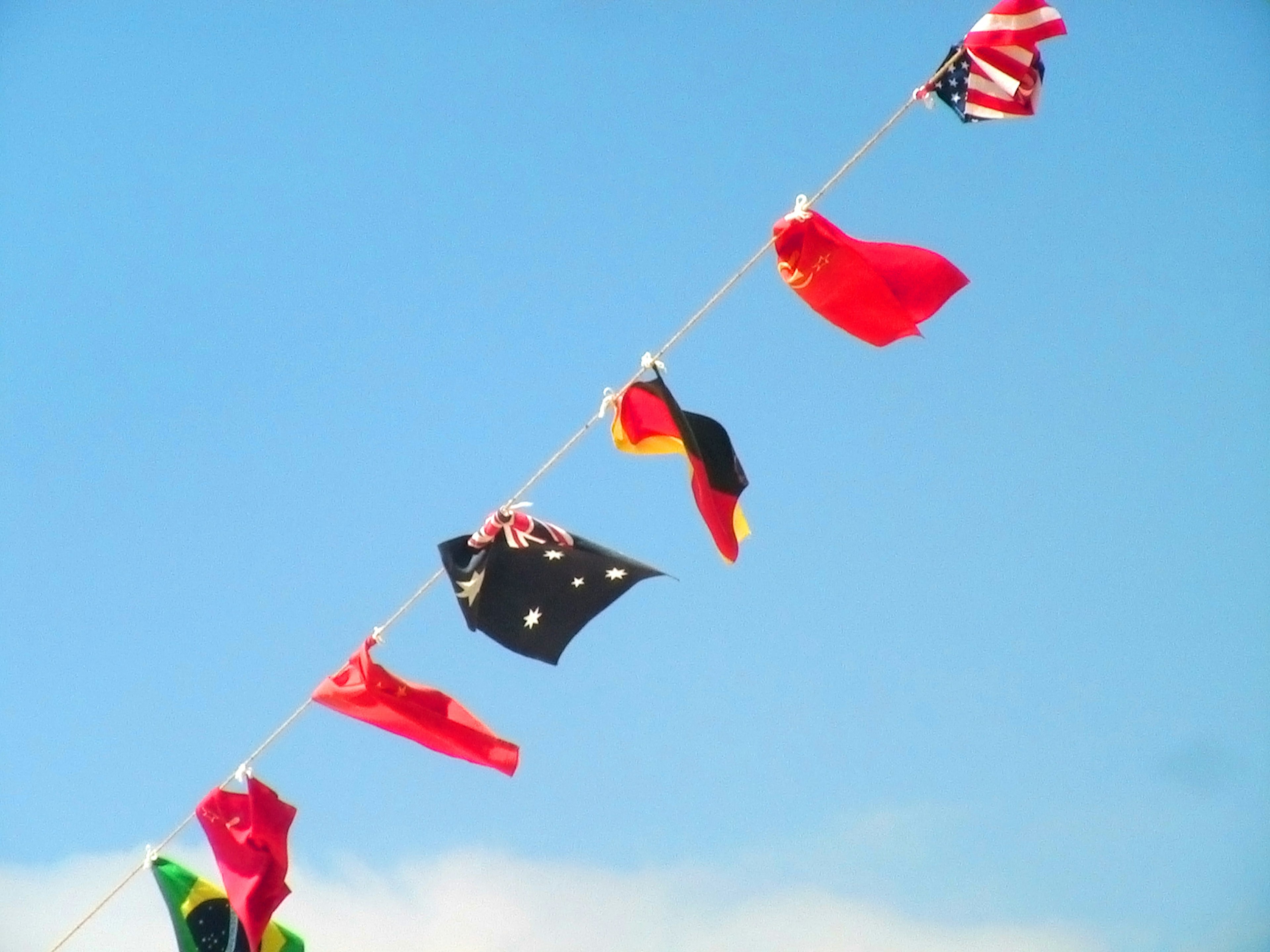 Girlande von Flaggen unter einem blauen Himmel mit verschiedenen Nationalflaggen