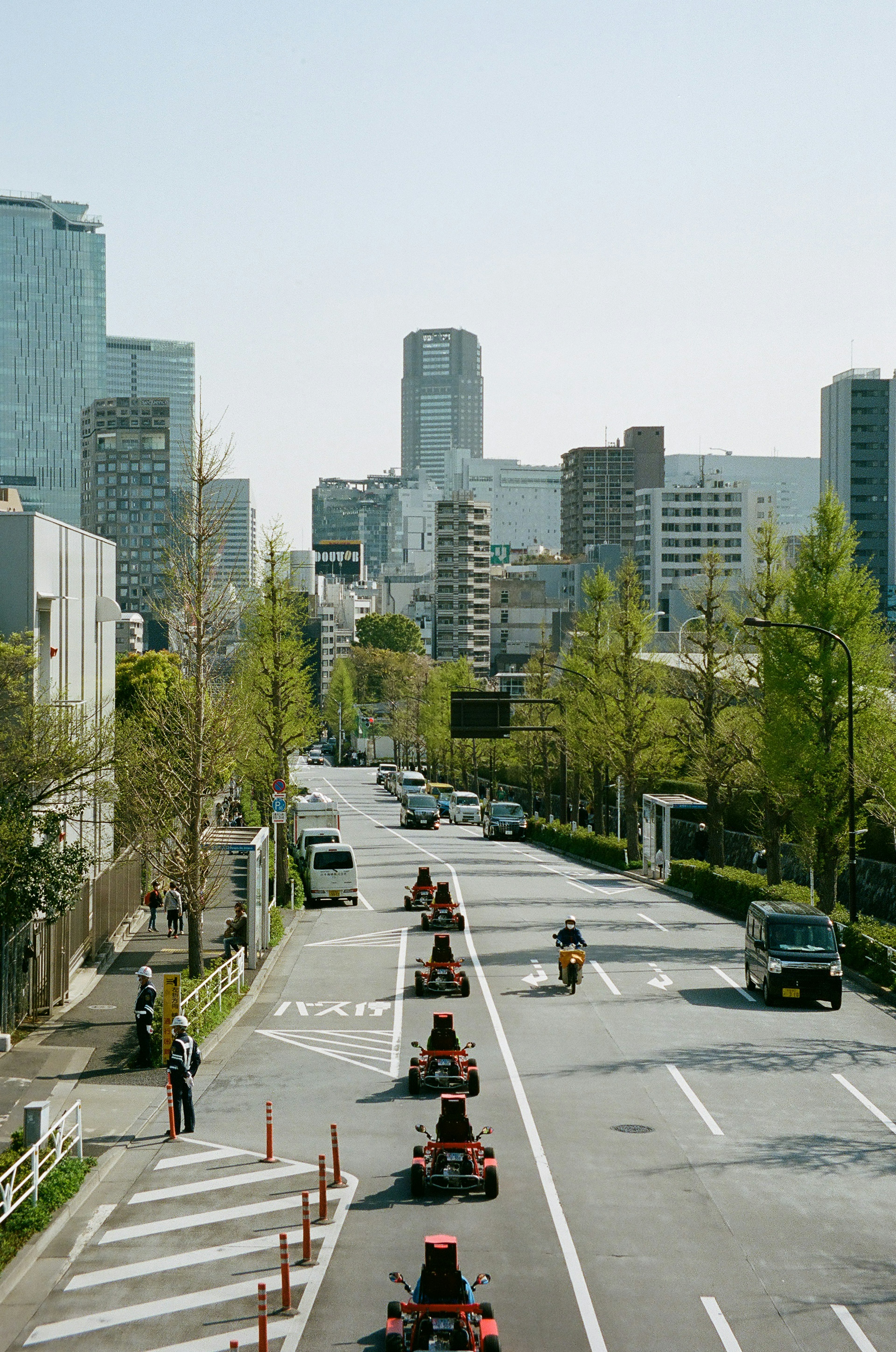 Line of go-karts on a street in Tokyo with skyscrapers