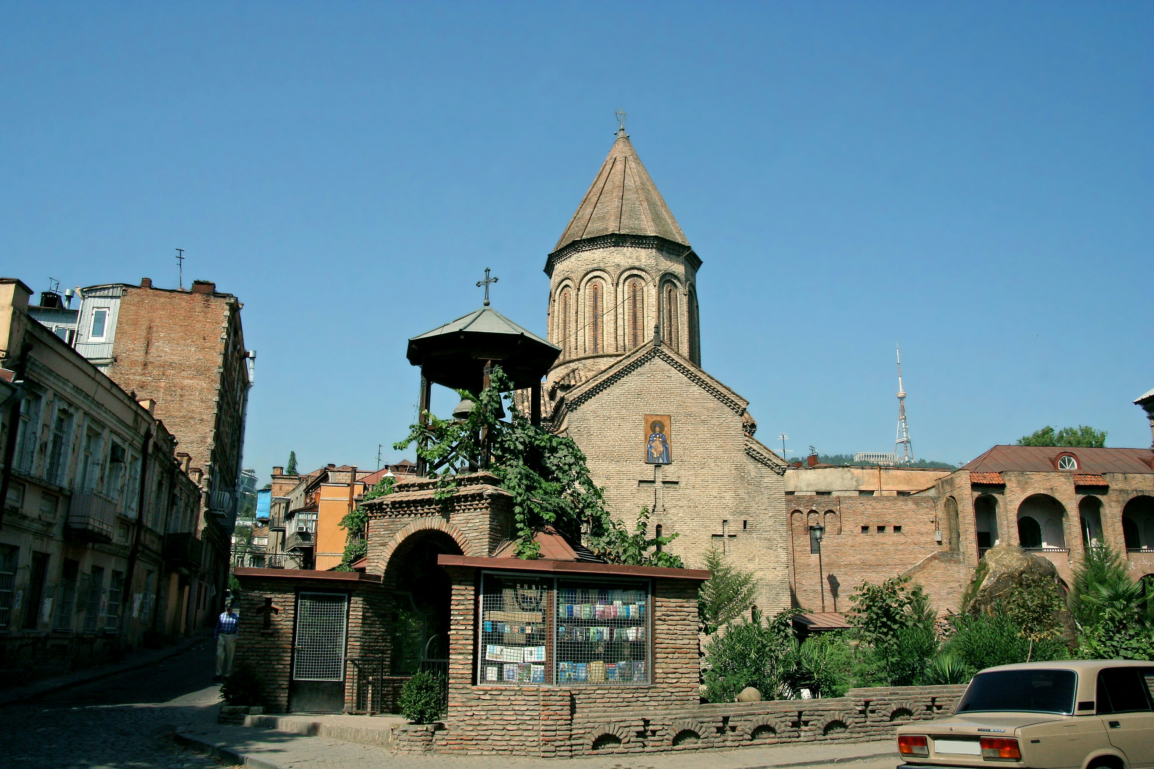 Historische Kirche mit umliegenden Gebäuden und klarem blauen Himmel